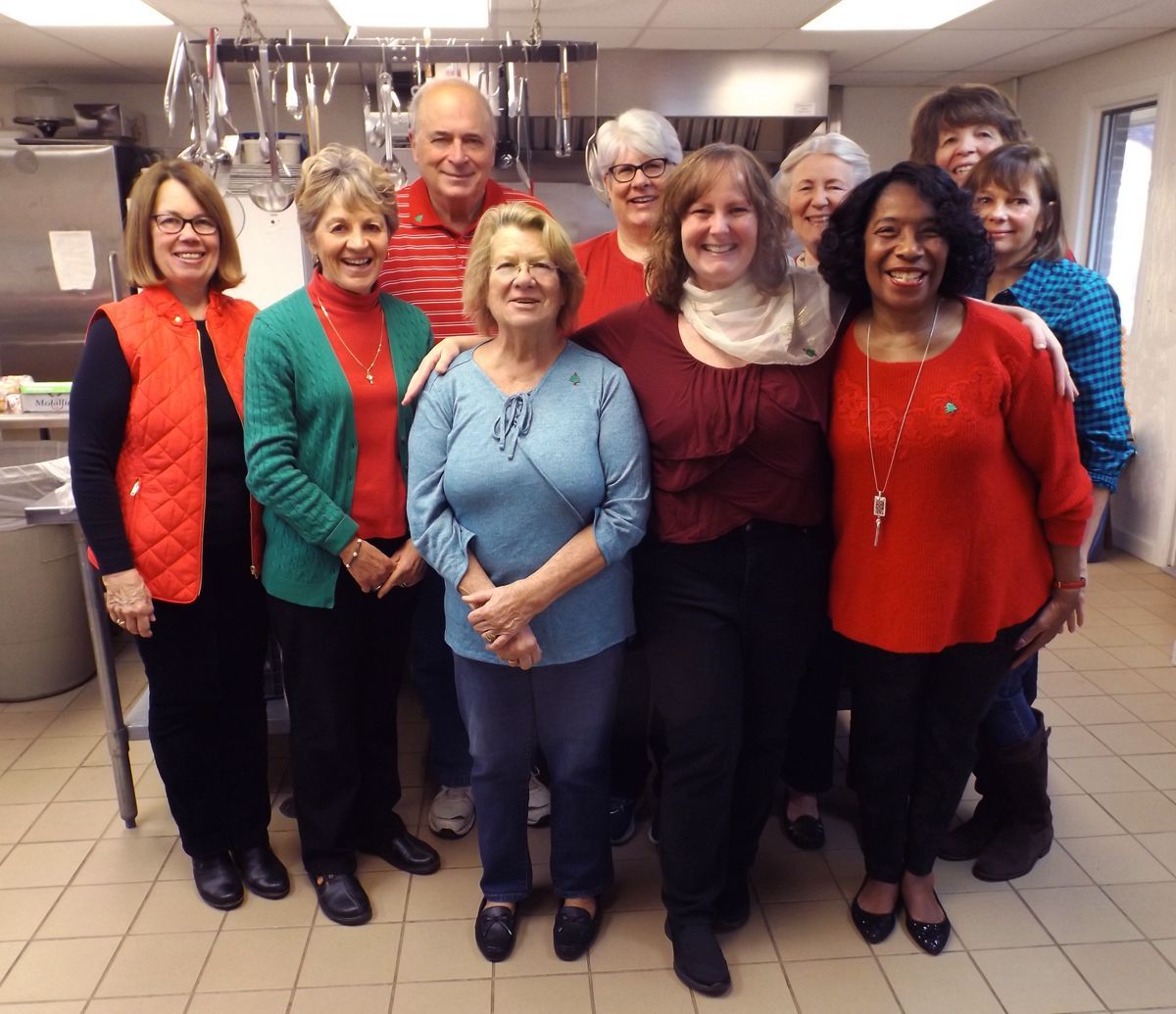 Members of the Hospitality Team stand grouped together in the church kitchen, smiling