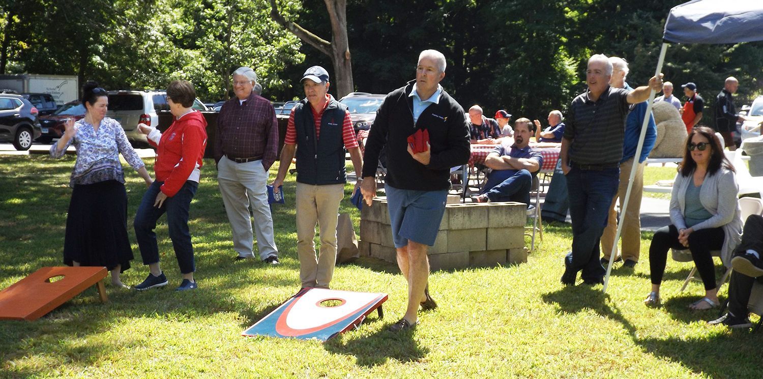 People play lawn games at a sunny outdoor gathering on the church lawn.