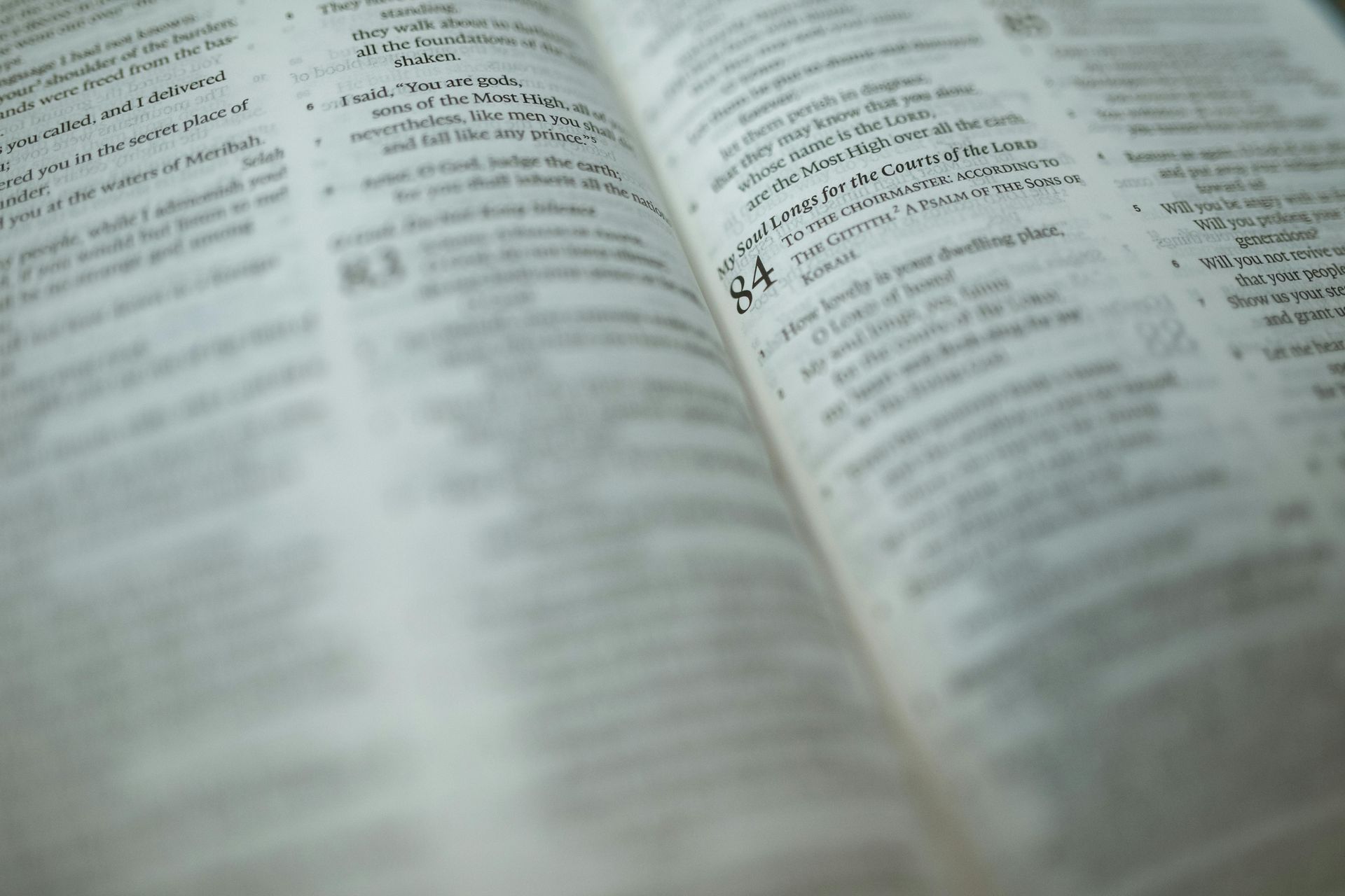 A Bible page showing chapters & verses is opened in soft light