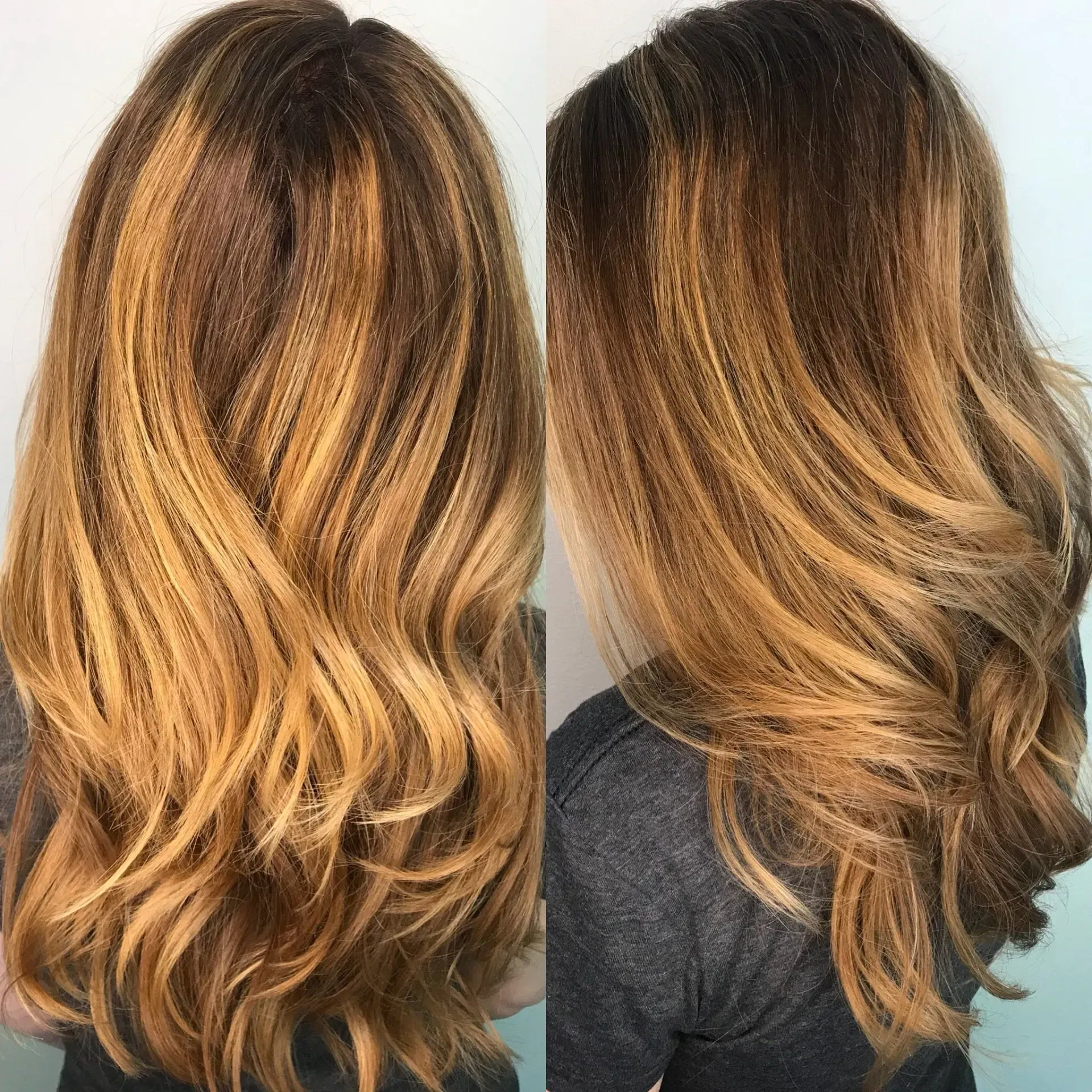 Back view of a wavy layered haircut with dark roots fading to golden blonde highlights