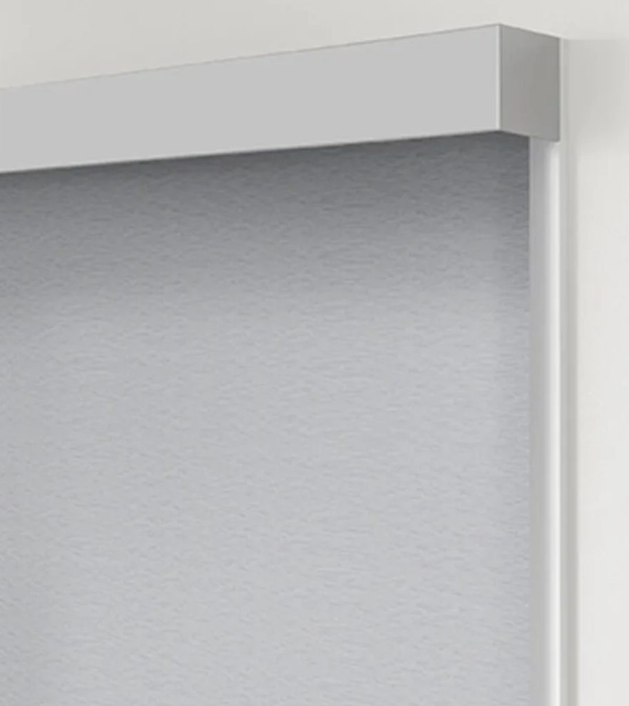 A close up of a white blind on a white wall.