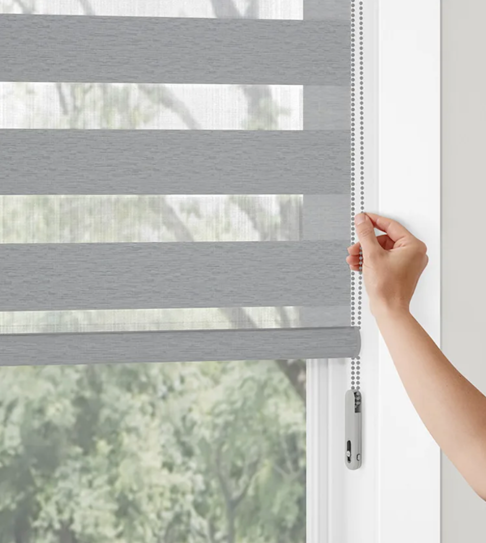 A person is adjusting a blind on a window.