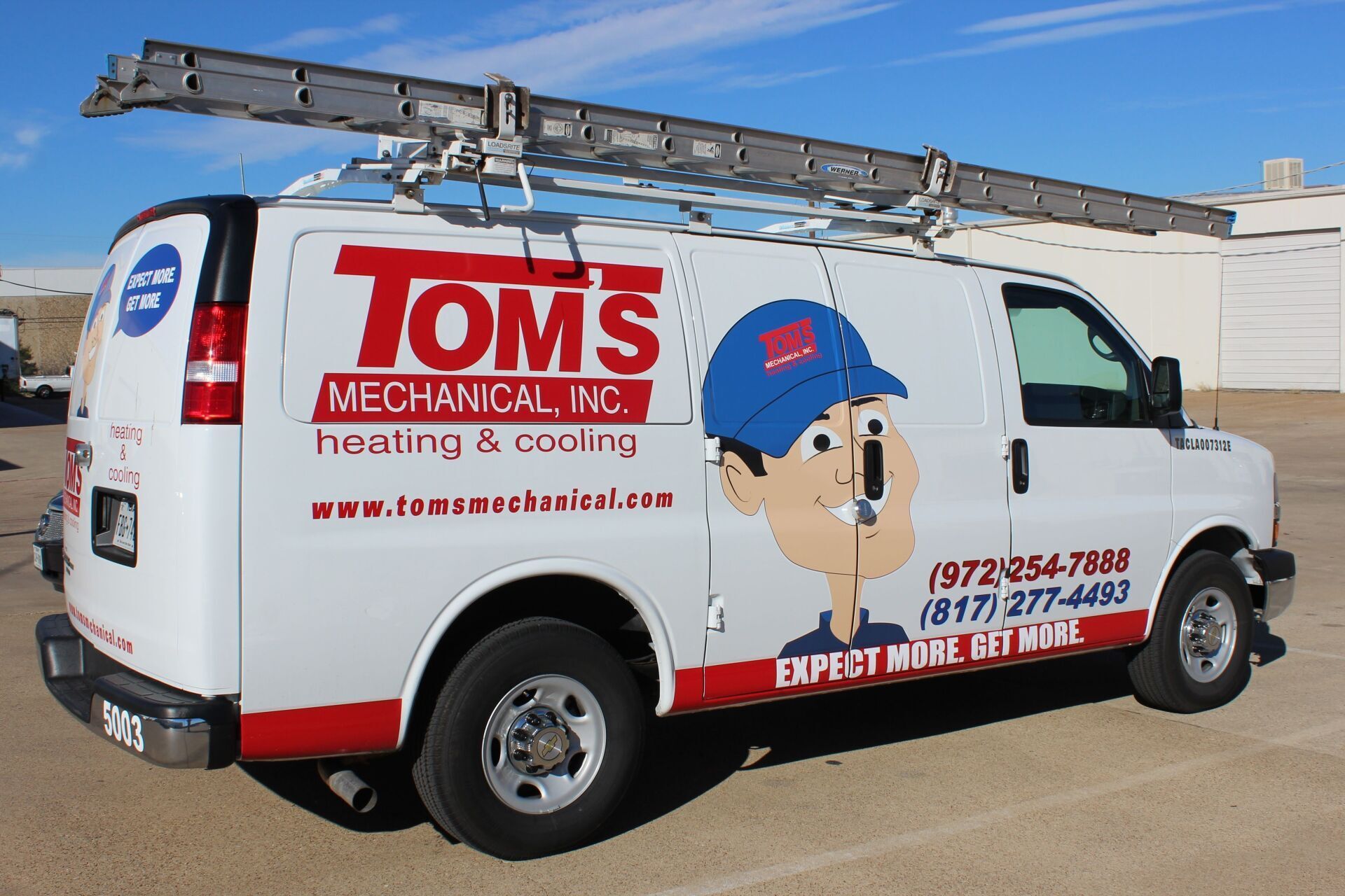 White Tom's Mechanical van with ladder on top, logo of a man in a hat. Phone number is visible.