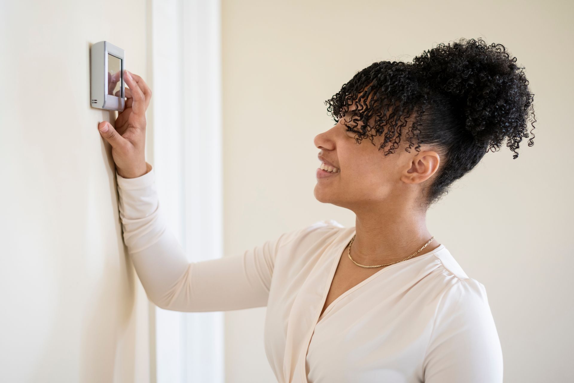 woman checking aux display on thermostat