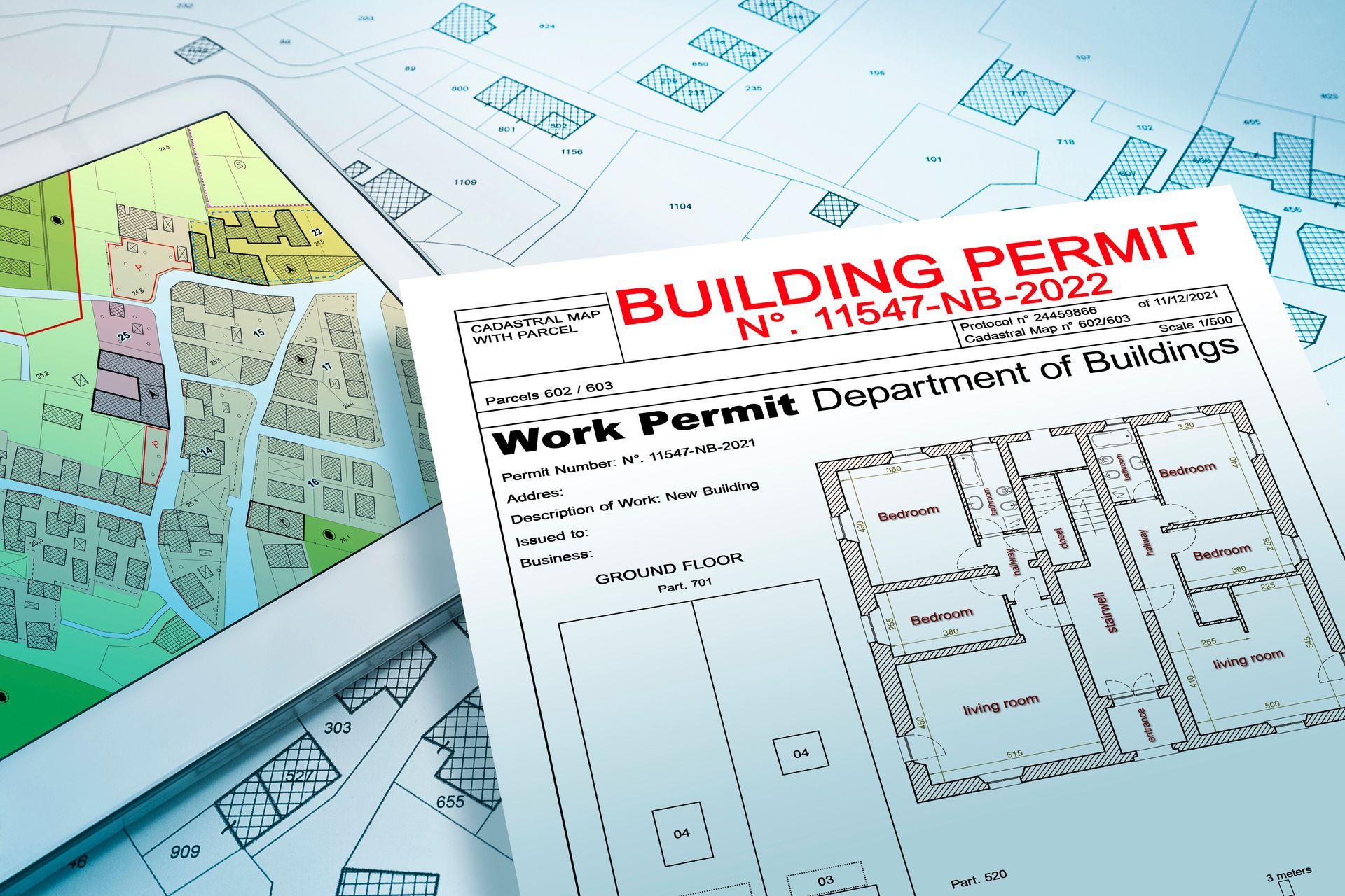 A building permit is sitting on top of a tablet