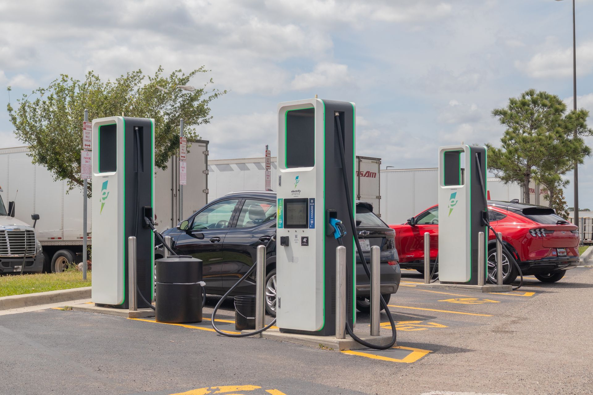 A car is being charged at a charging station in a parking lot.