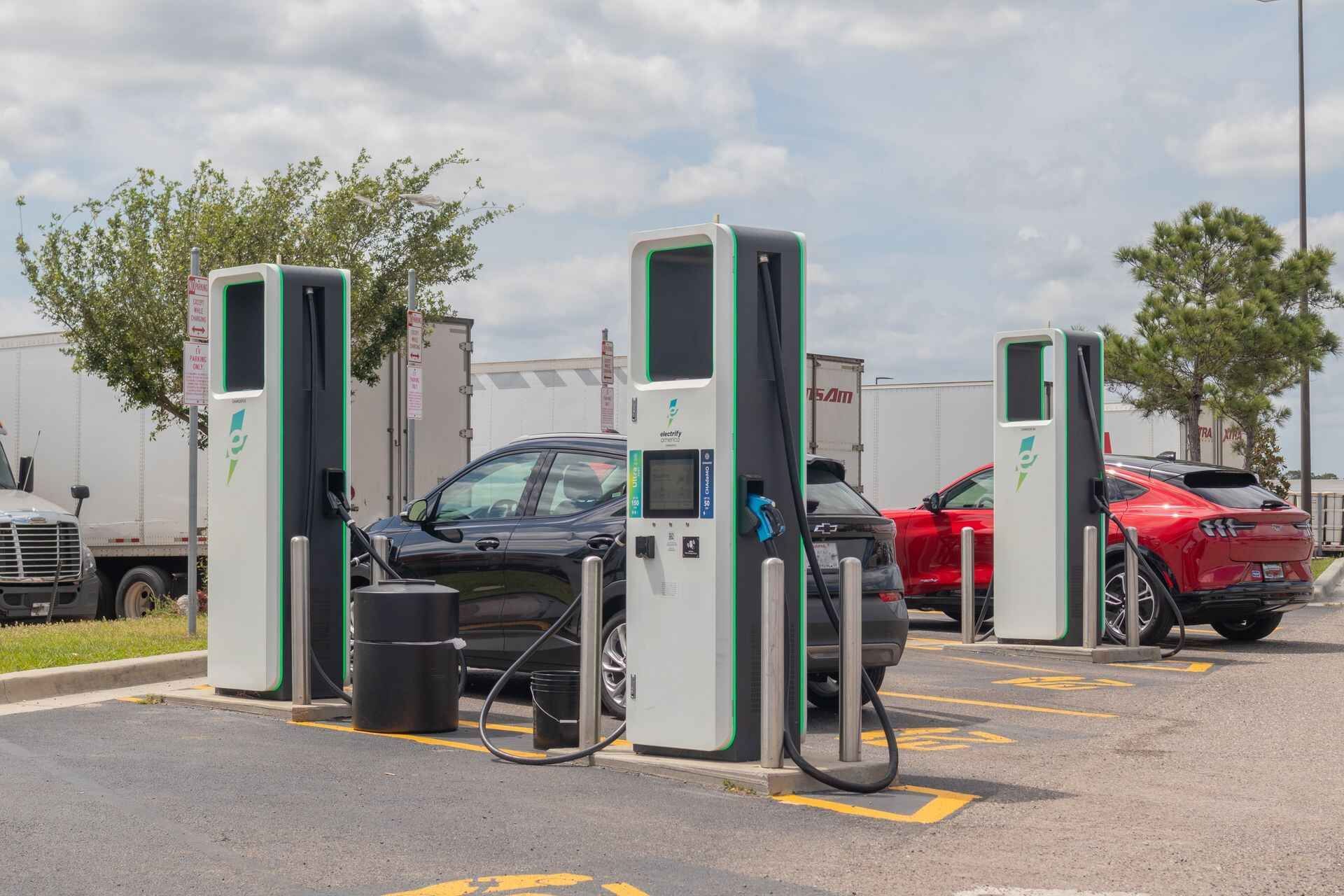 A car is being charged at a charging station in a parking lot.