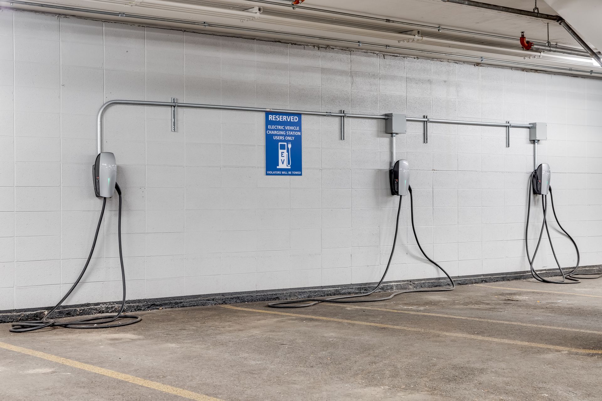 A parking garage with a lot of charging stations on the wall