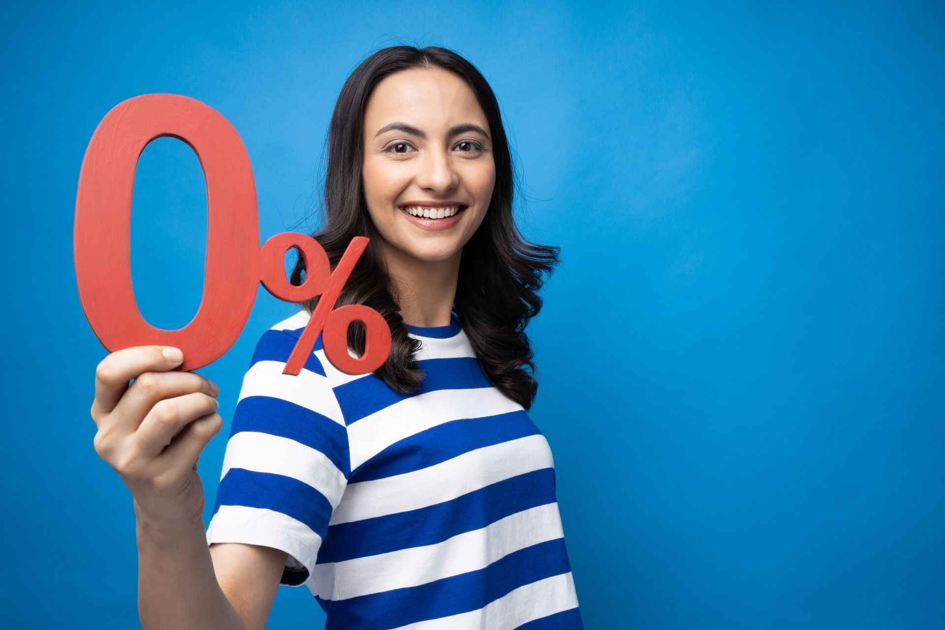 A woman in a striped shirt is holding a 0 percent sign.