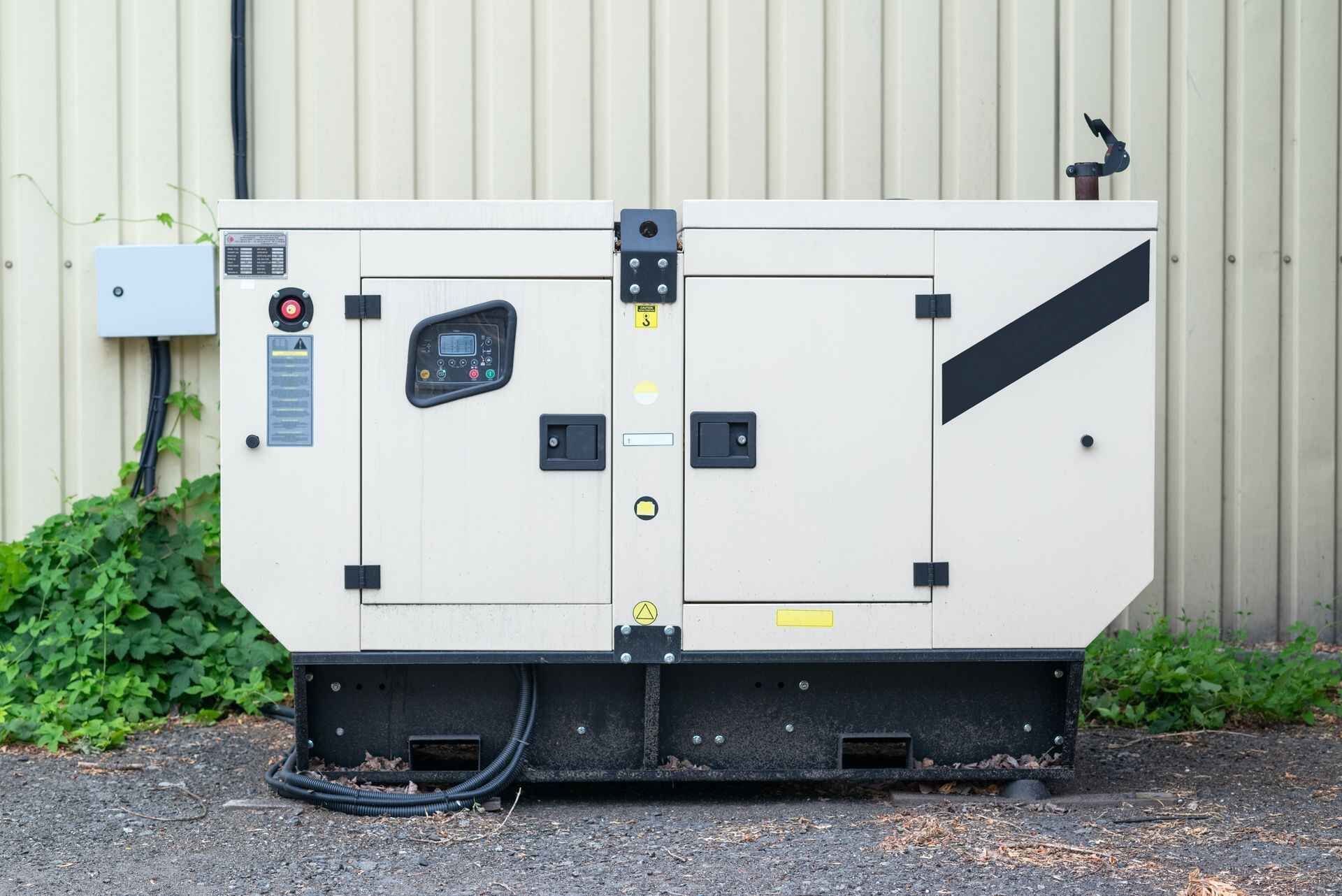 A white and black generator is parked in front of a building.