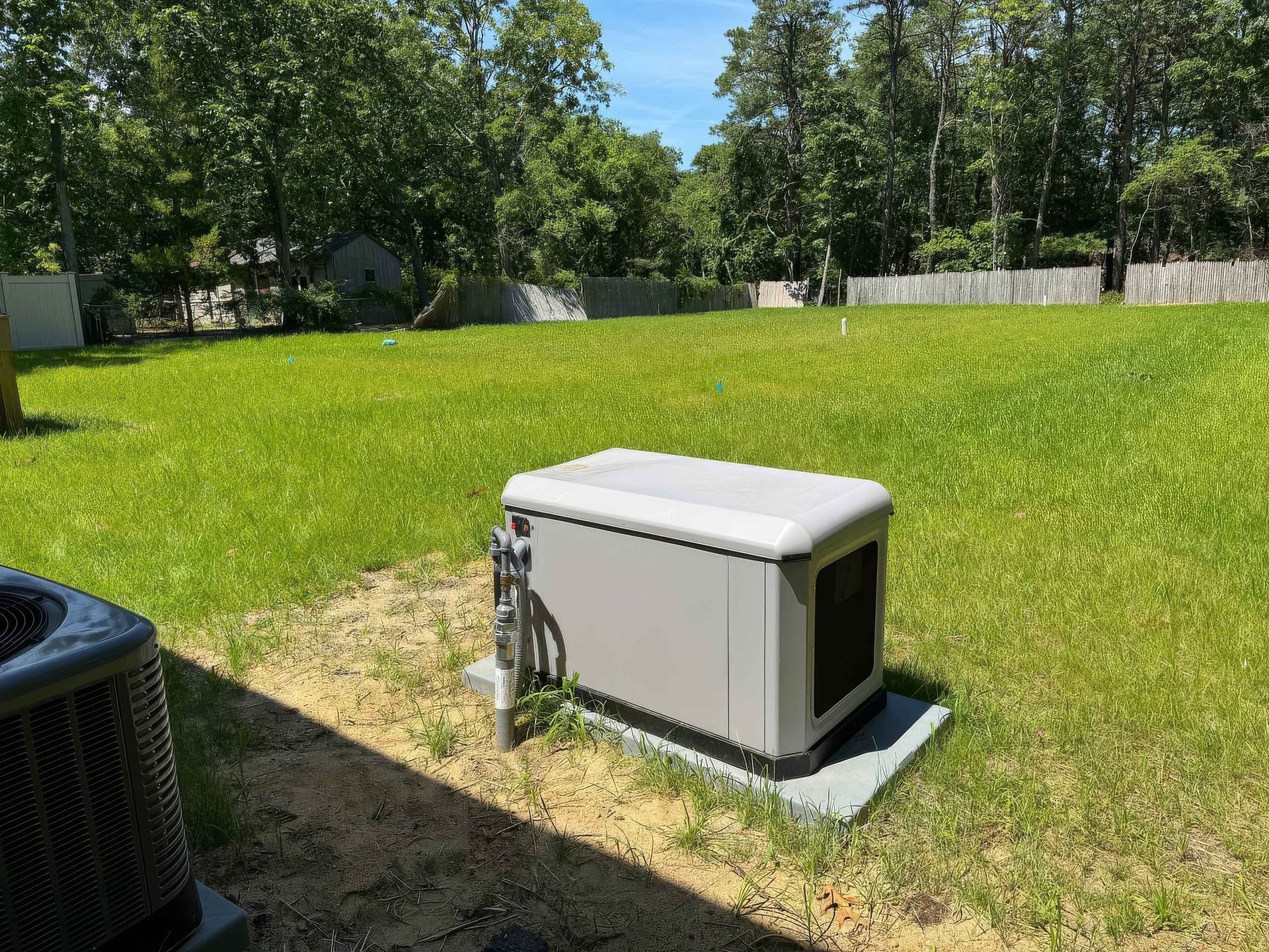 A generator is sitting in the middle of a lush green field.