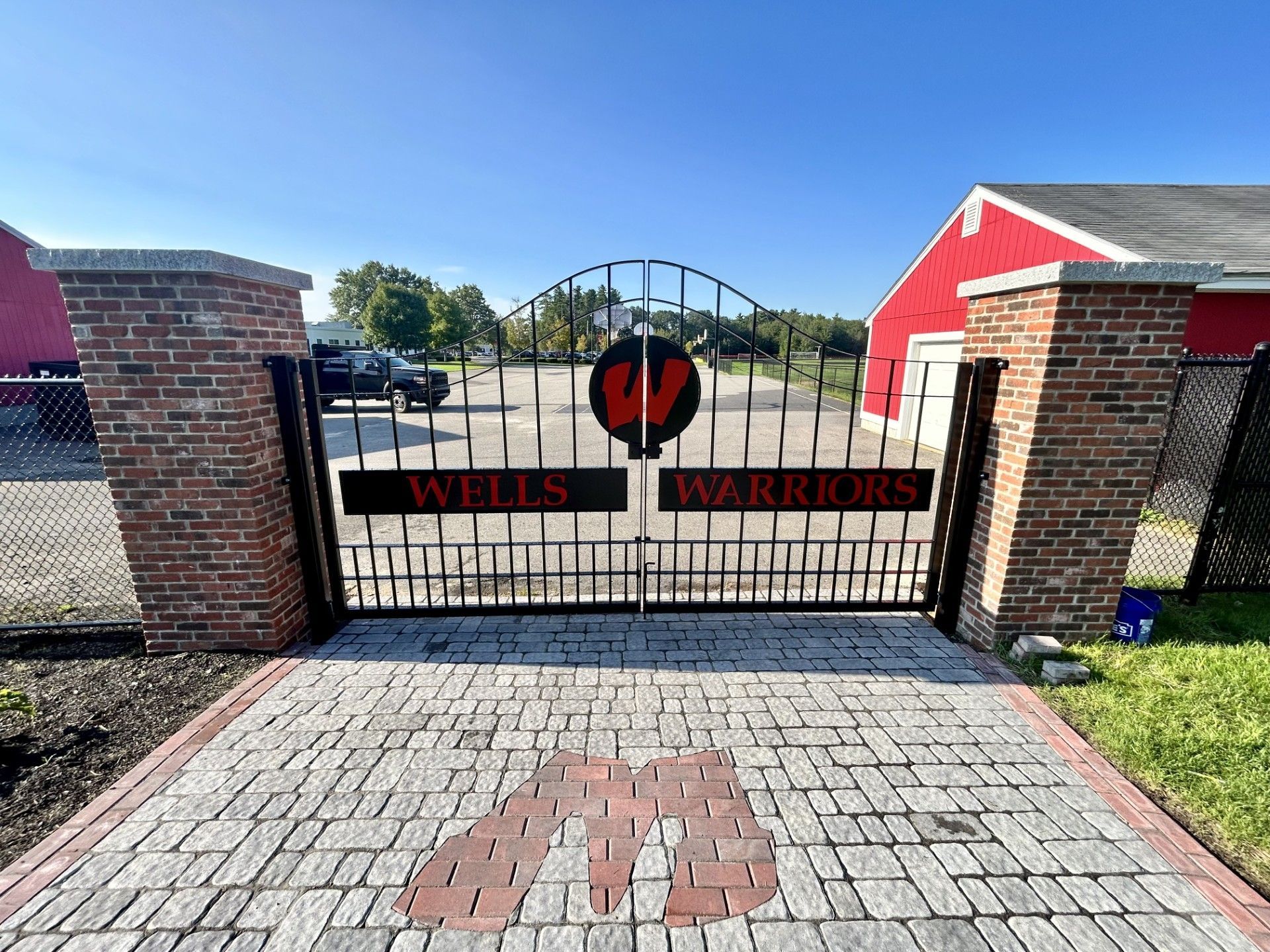 Brick pillars flank a metal gate labeled