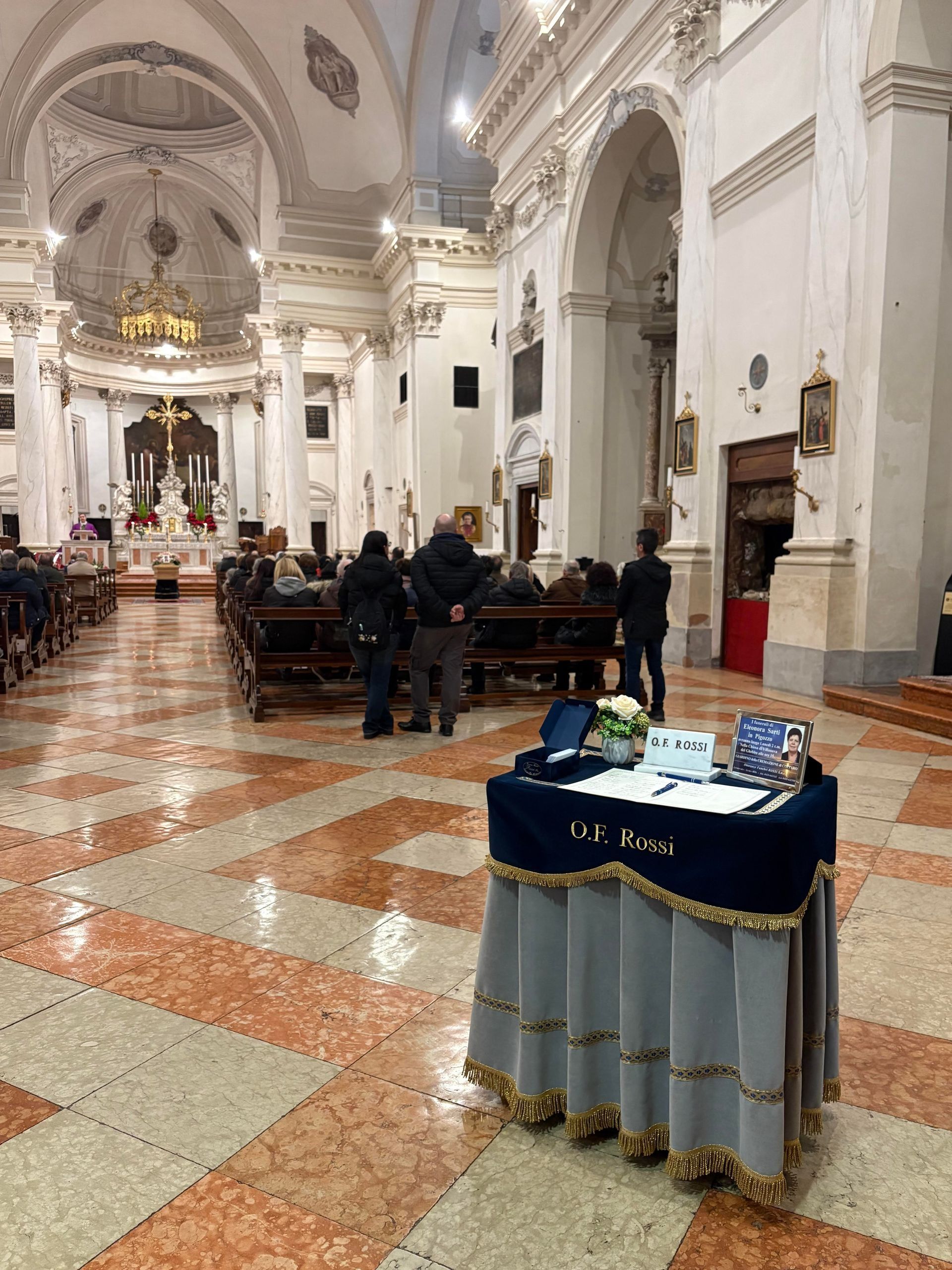 Ornate church interior with pews, altar, and a decorated table in the foreground