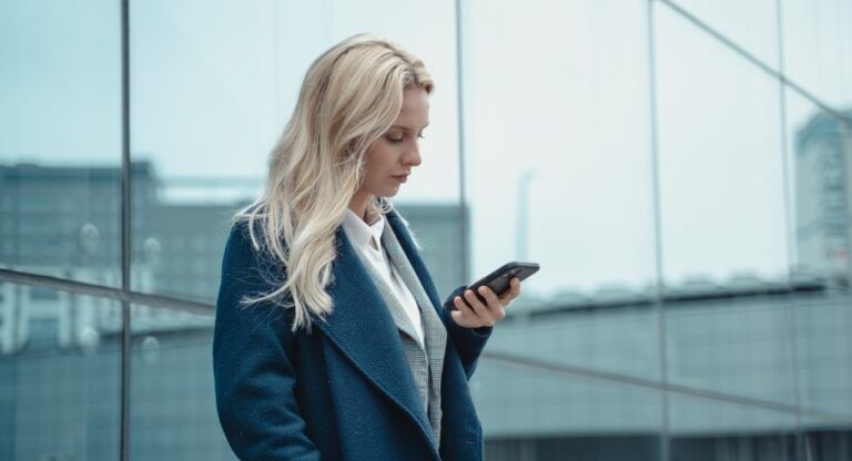 A woman checking her phone while waiting for a response, the emotional impact of being ghosted