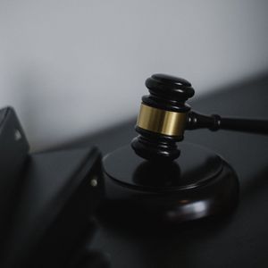 A judge's gavel is sitting on top of a black table.