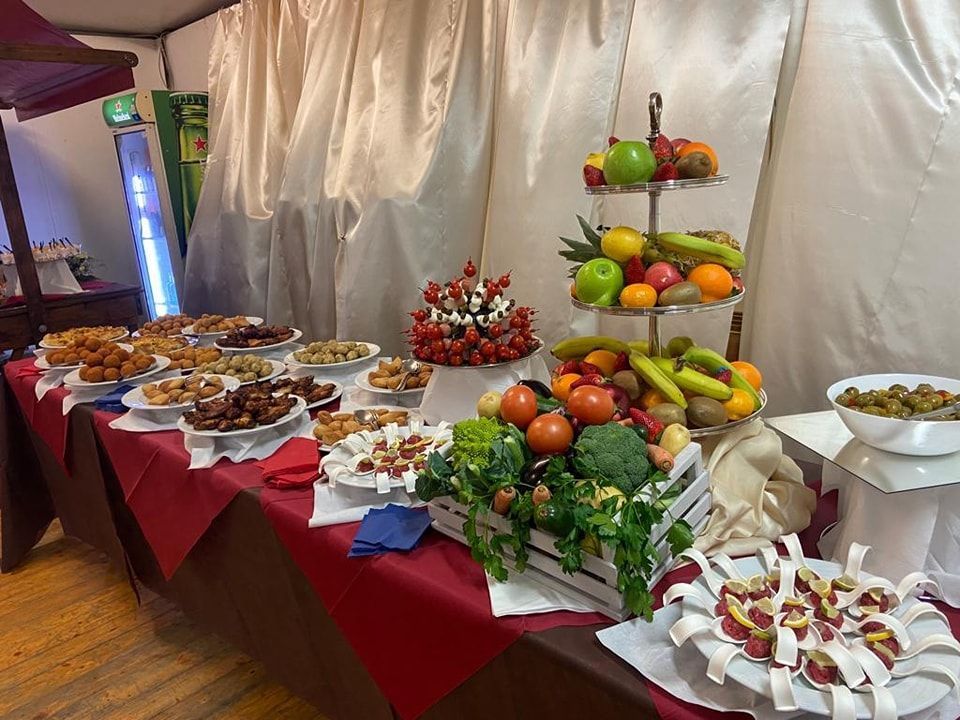 Un tavolo da buffet con una varietà di cibo e frutta.