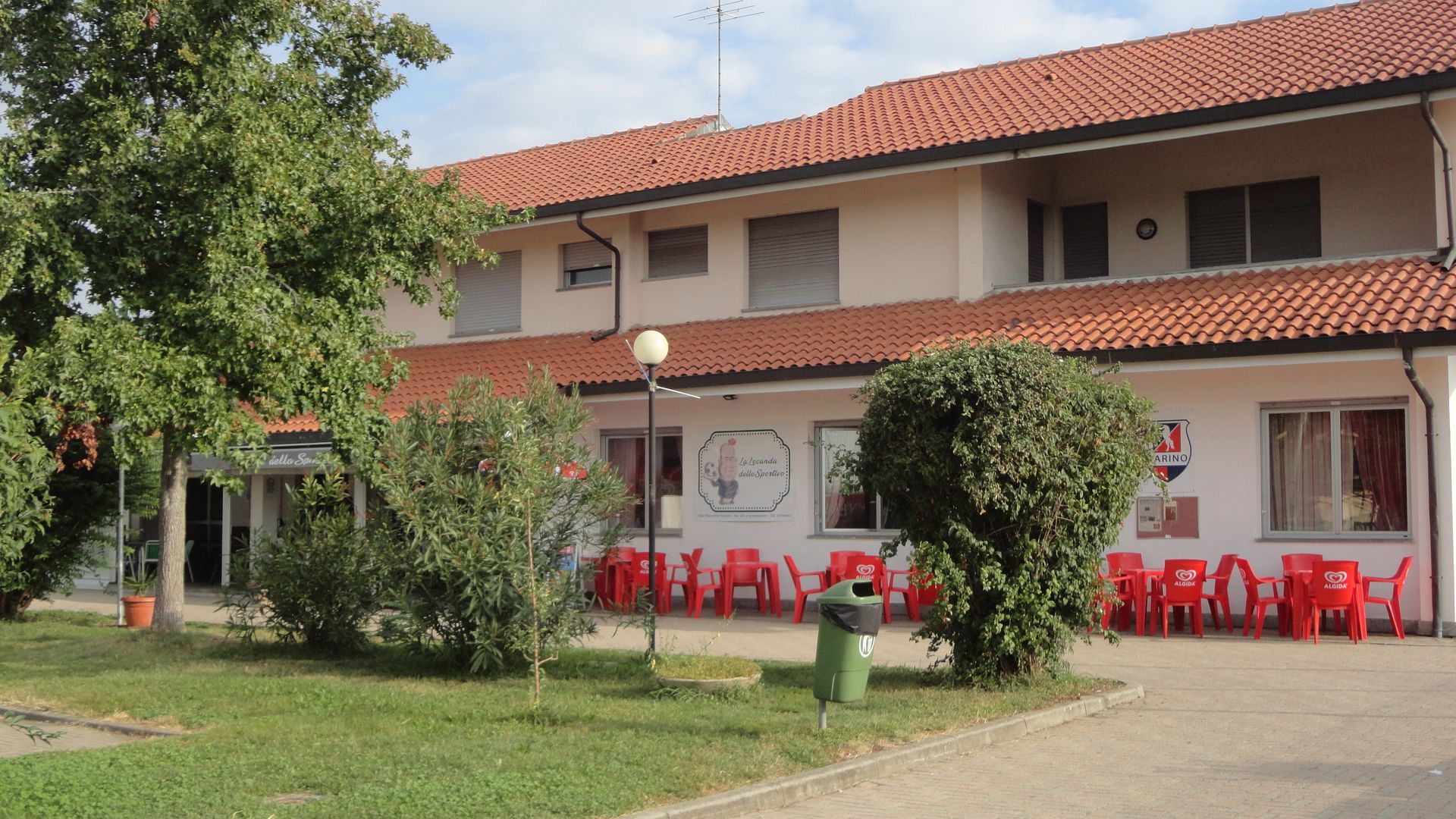 Un grande edificio bianco con un tetto di tegole rosse