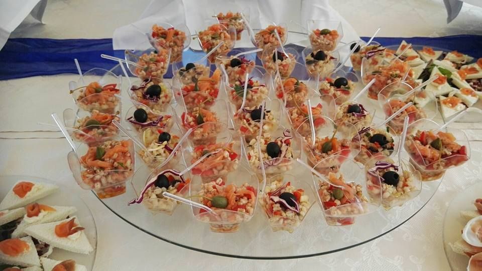 Un piatto di vetro sormontato da una varietà di cibo su bastoncini.