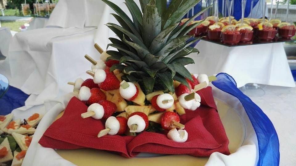 Un ananas decorato con frutta e formaggio infilzato su uno spiedino su un tavolo.