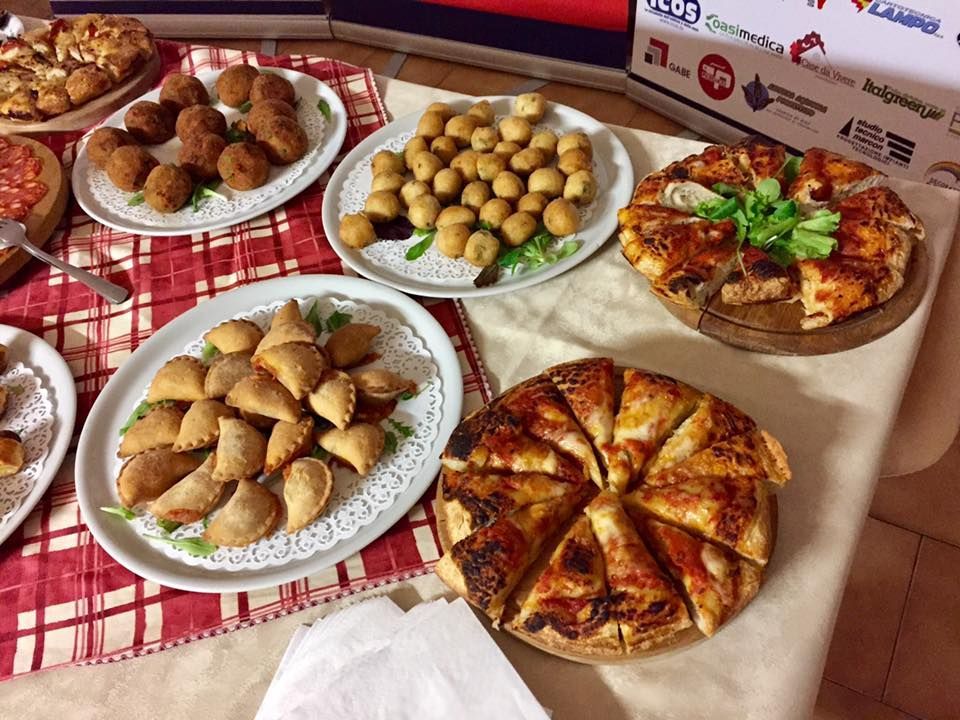 Un tavolo sormontato da piatti di cibo tra cui pizza e antipasti