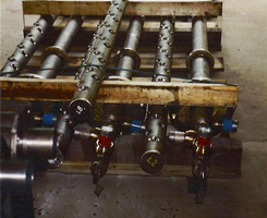 A bunch of metal pipes are stacked on top of each other on a wooden pallet