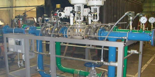 A machine with blue and green pipes and valves in a factory