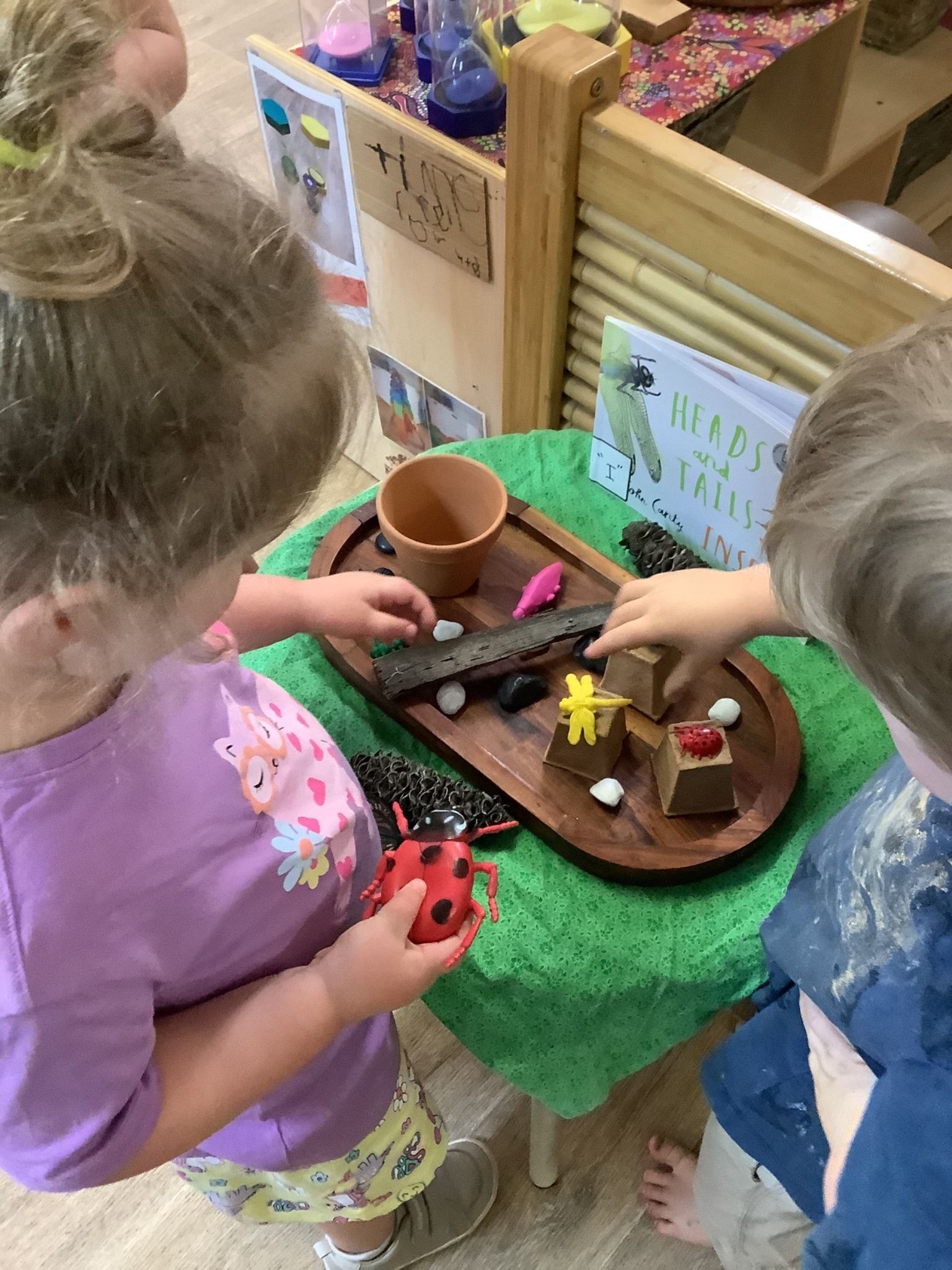 Two young children playing with toys on a wooden tray, exploring a nature-themed setup — Kinburra Preschool (Kincumber) in Kincumber, NSW