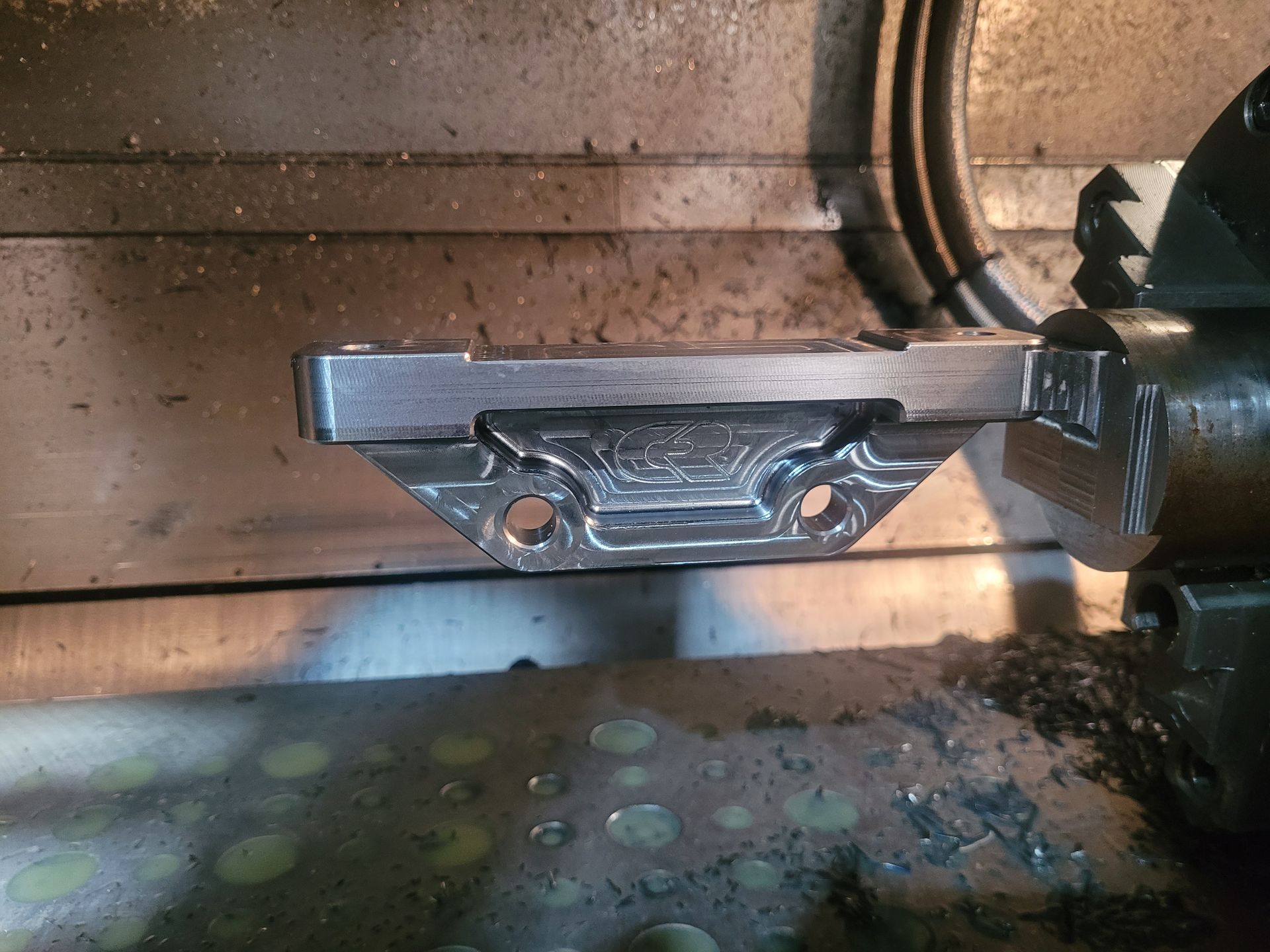 Metal machine part with bolts and a textured plate inside a dim industrial enclosure — Real Engineering In Gosford, NSW