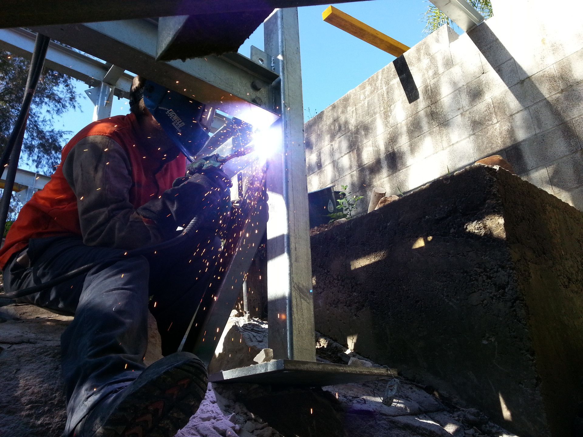 A Welder Wearing Protective Gear Works on A Metal Structural Post — Real Engineering in West Gosford, NSW