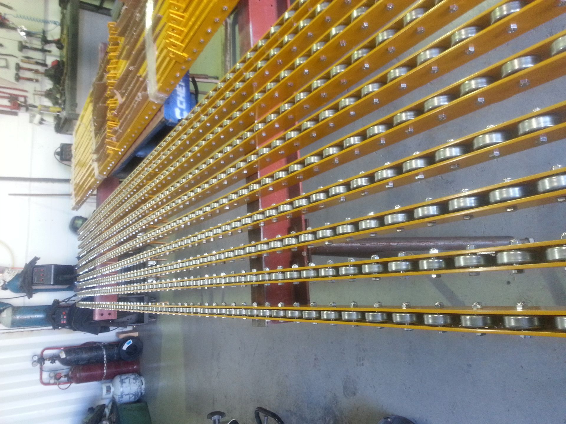 Rows of Yellow Metal Channels Equipped with Small, Evenly Spaced Silver Rollers — Real Engineering in West Gosford, NSW