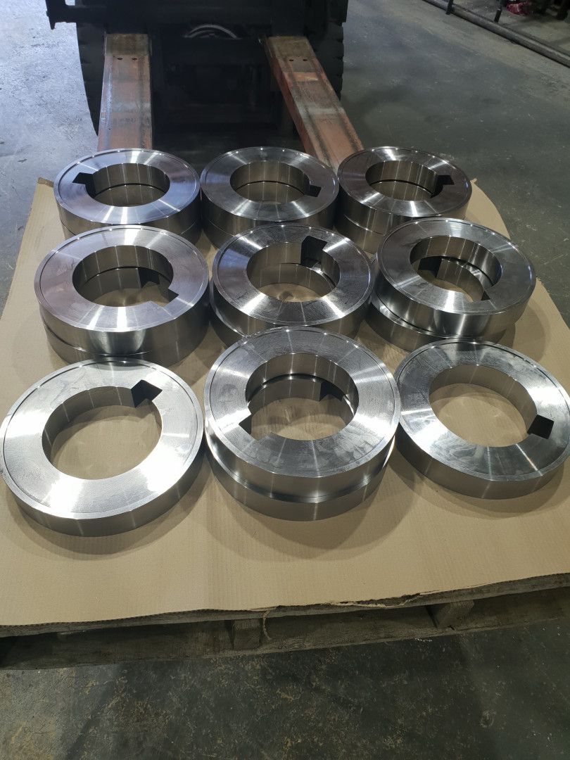 Eight Metal Circular Rings with Keyways Arranged on A Wooden Pallet — Real Engineering in West Gosford, NSW