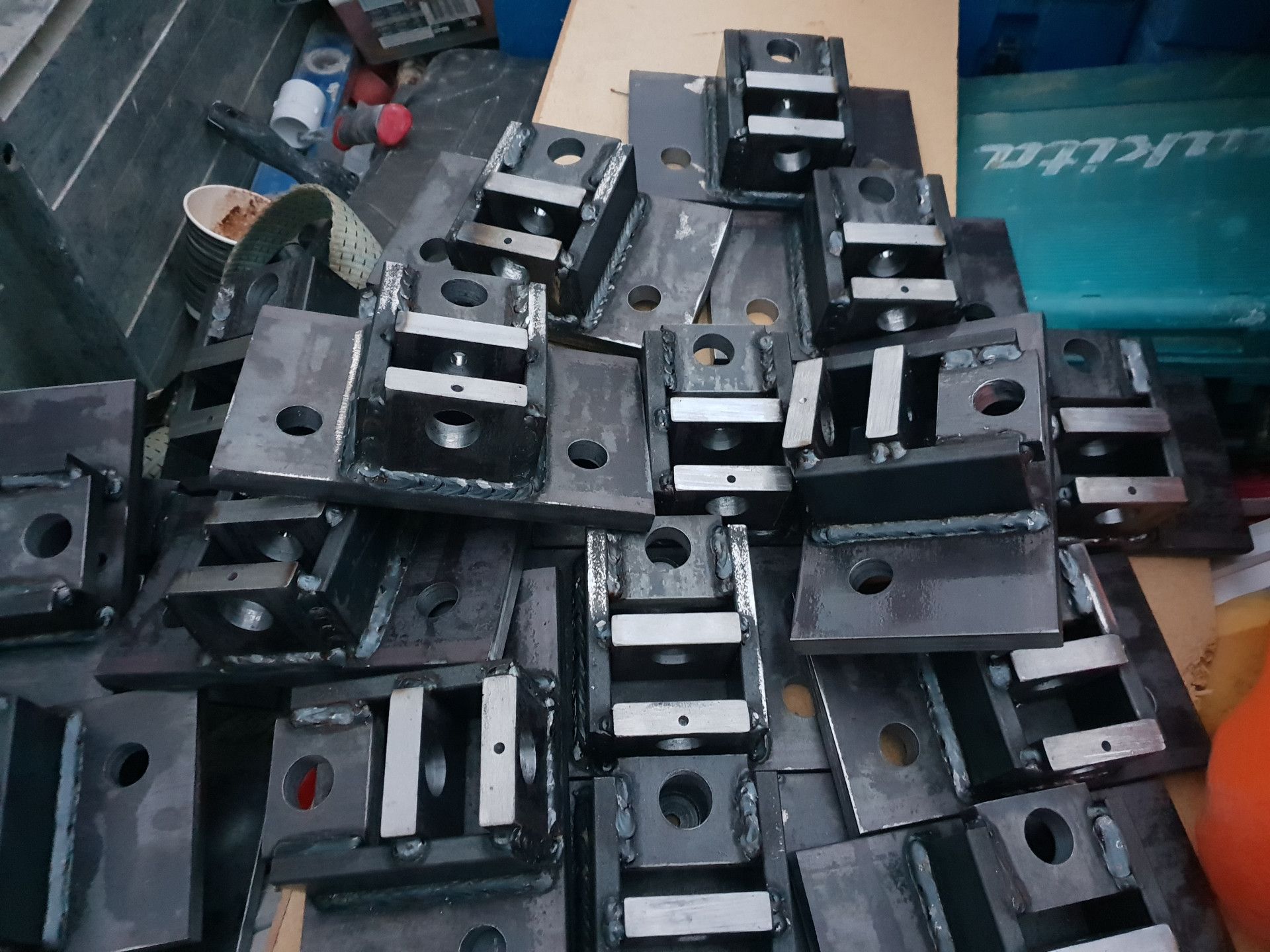 A Pile of Dark Grey Metal Mounting Brackets — Real Engineering in West Gosford, NSW