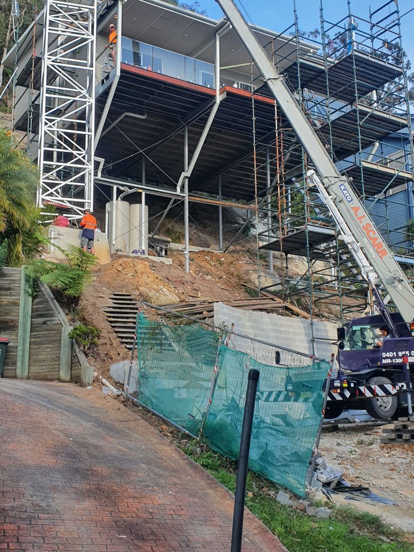 A Crane Lifts Materials to A Modern Multi-Story House Under Construction — Real Engineering in West Gosford, NSW