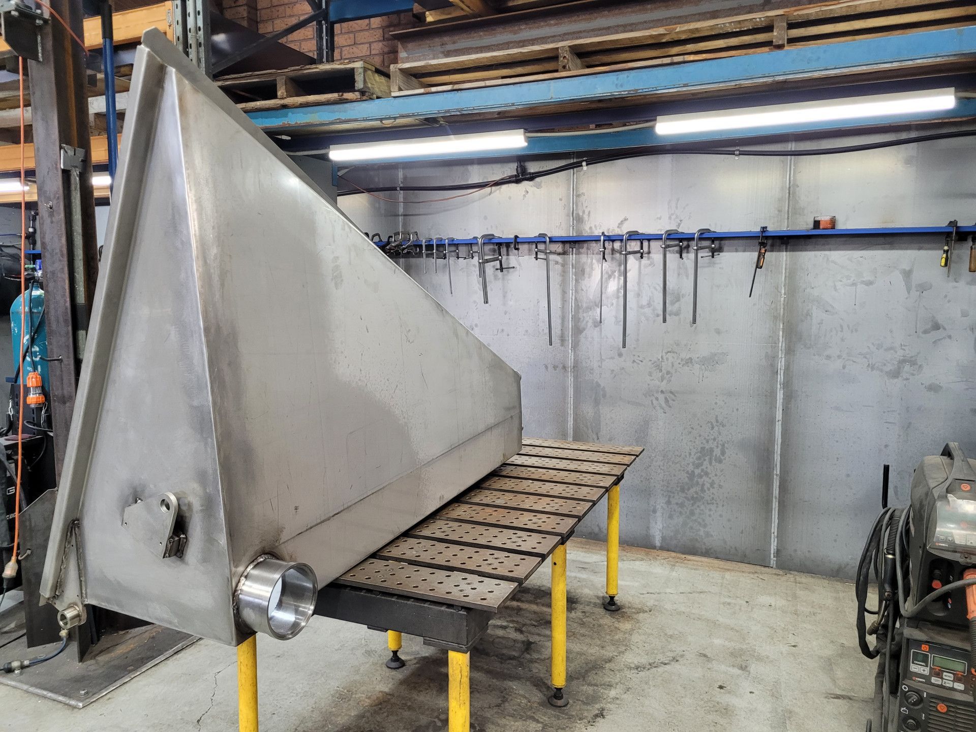 A Large, Stainless Steel Triangular Tank Rests on A Metal Welding Table — Real Engineering in West Gosford, NSW