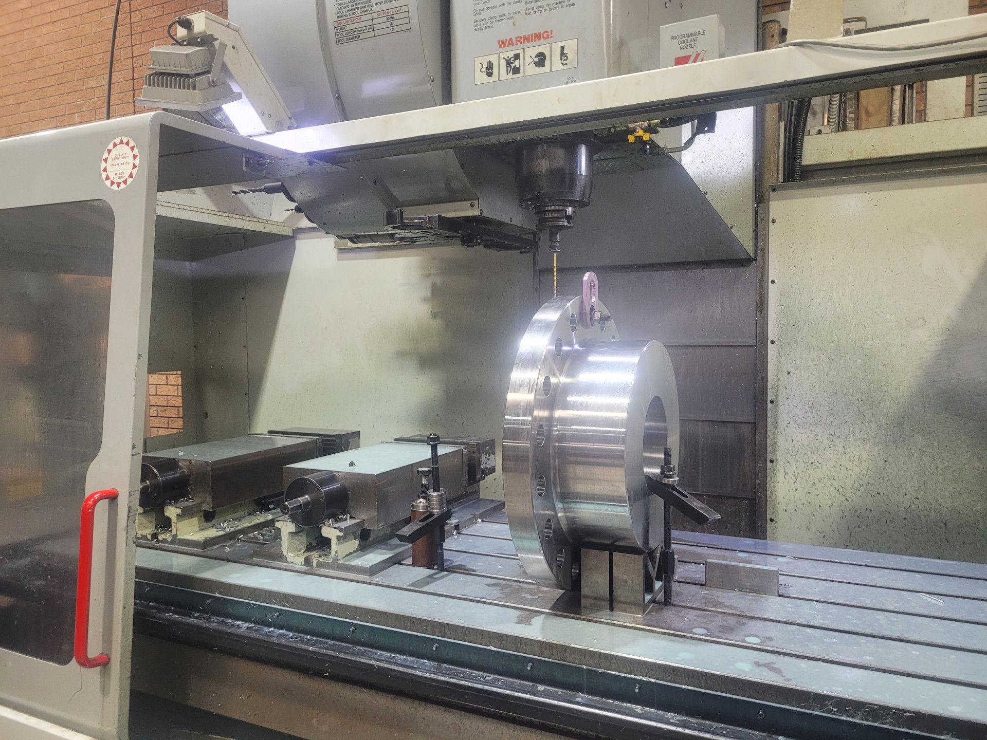A Cylindrical Metal Workpiece Is Secured on The Bed of A Cnc Milling Machine — Real Engineering In West Gosford, NSW