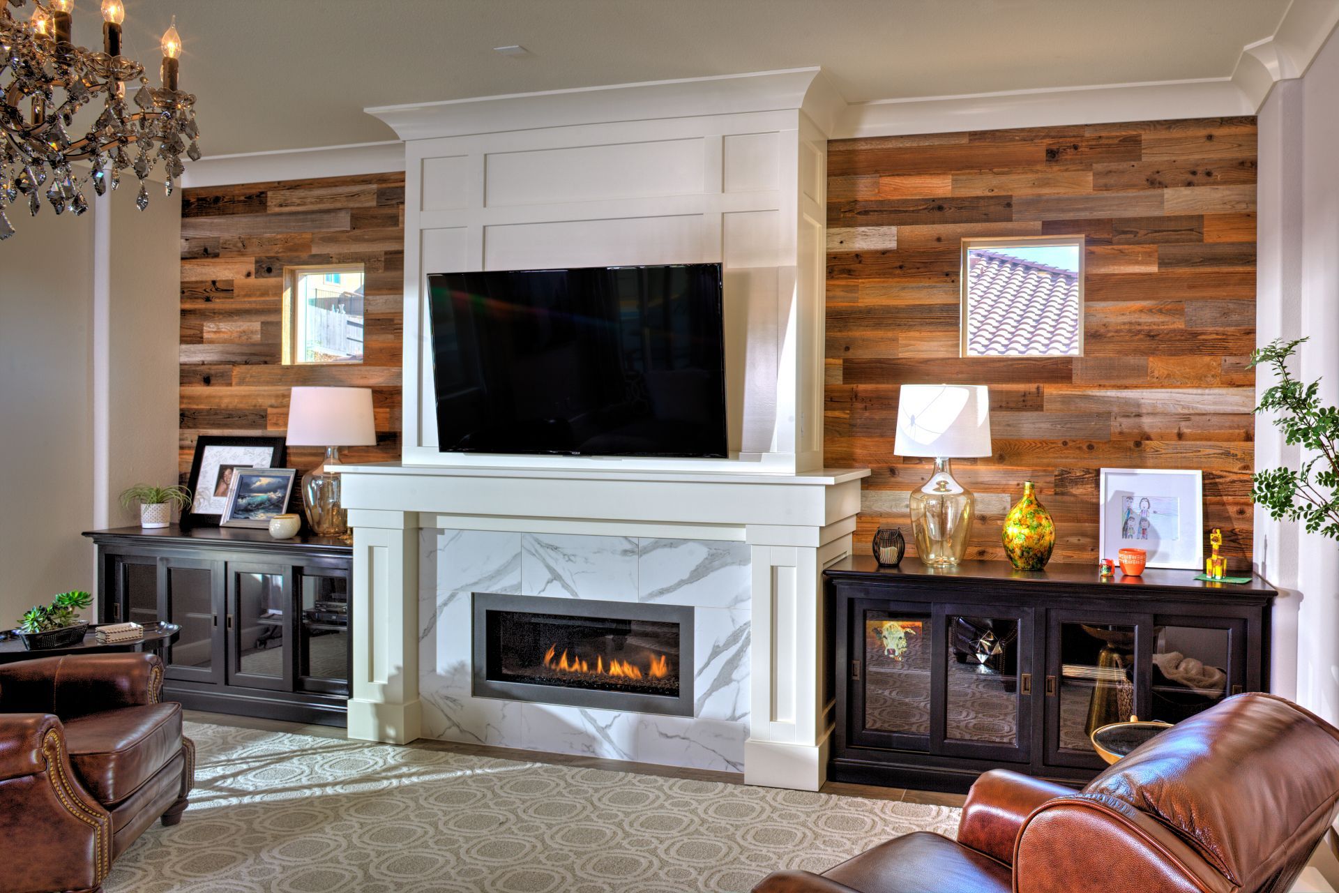 Living room with a fireplace, TV, and wood paneling, dark furniture, and leather chairs.