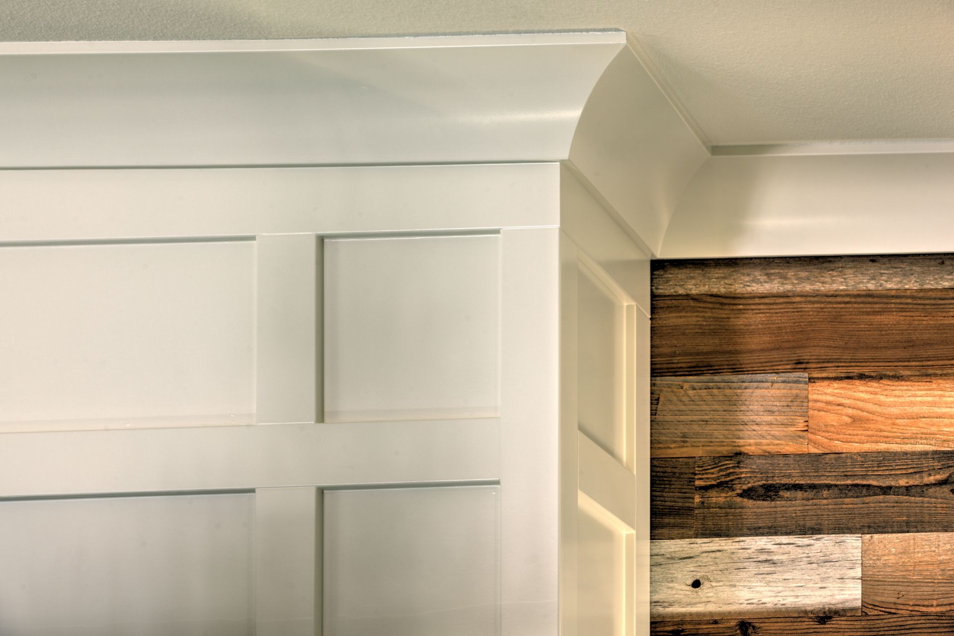 White paneled wall with crown molding next to a wall of wooden planks.