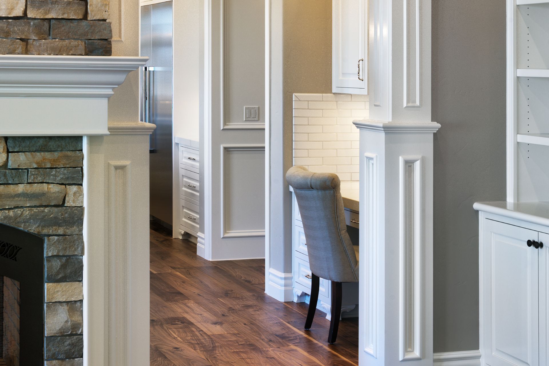 Interior hallway with white trim, dark wood floors, and a built-in desk.
