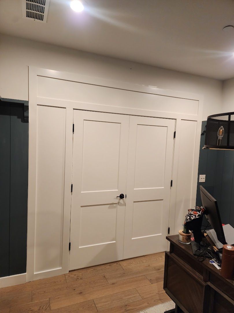 White double doors with transom window in a beige interior hallway, partially open.
