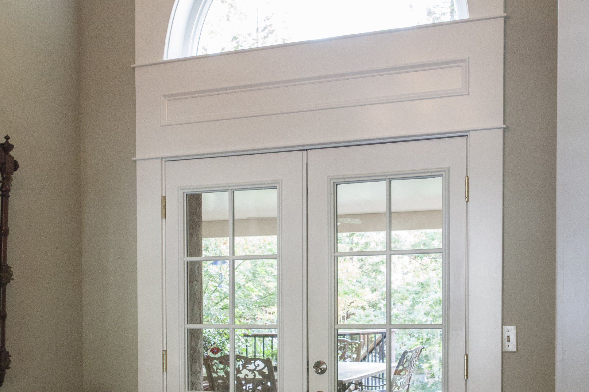 White French doors with glass panes and an arched window above.