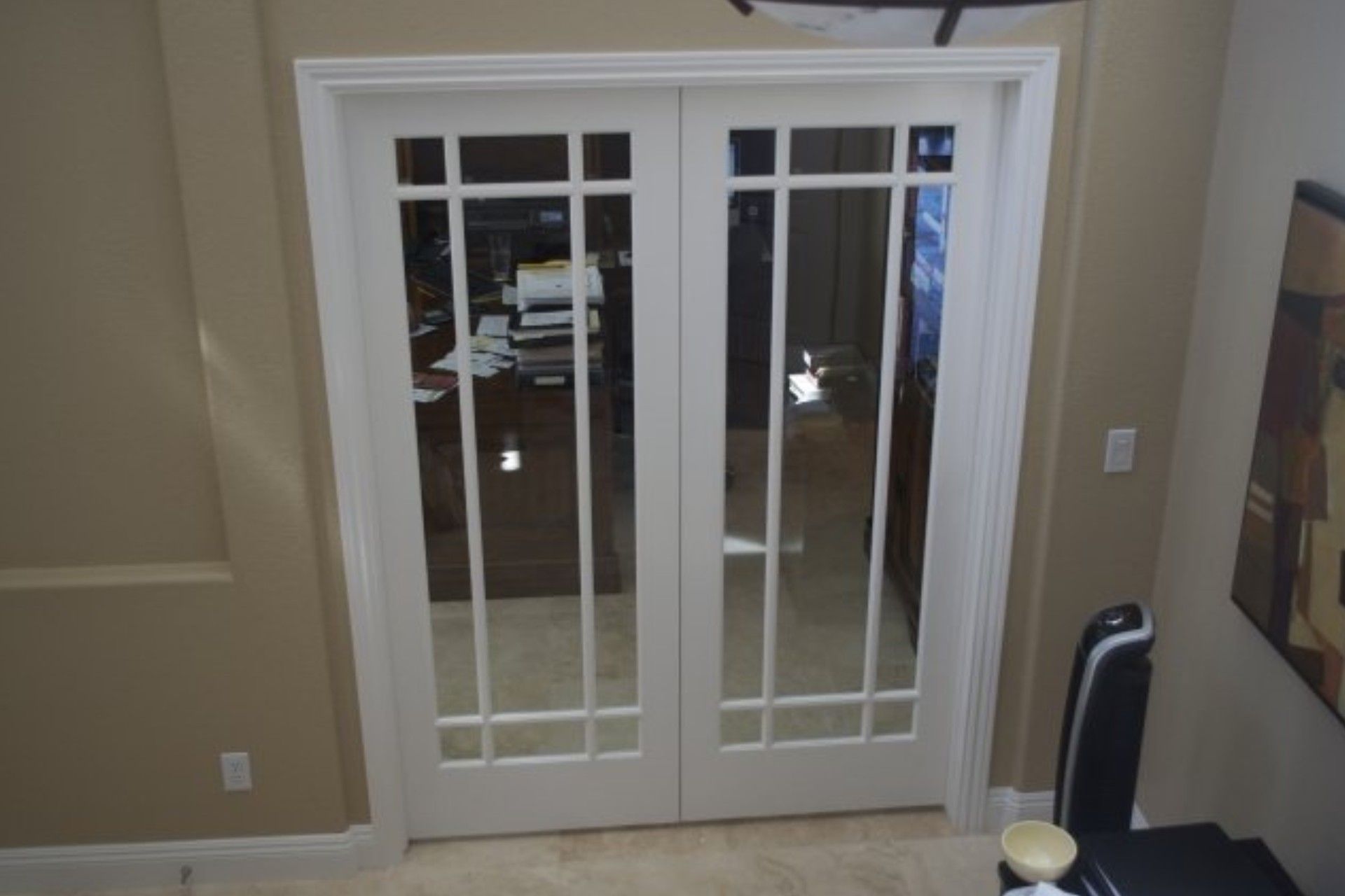 White French doors with glass panes set in a tan room.