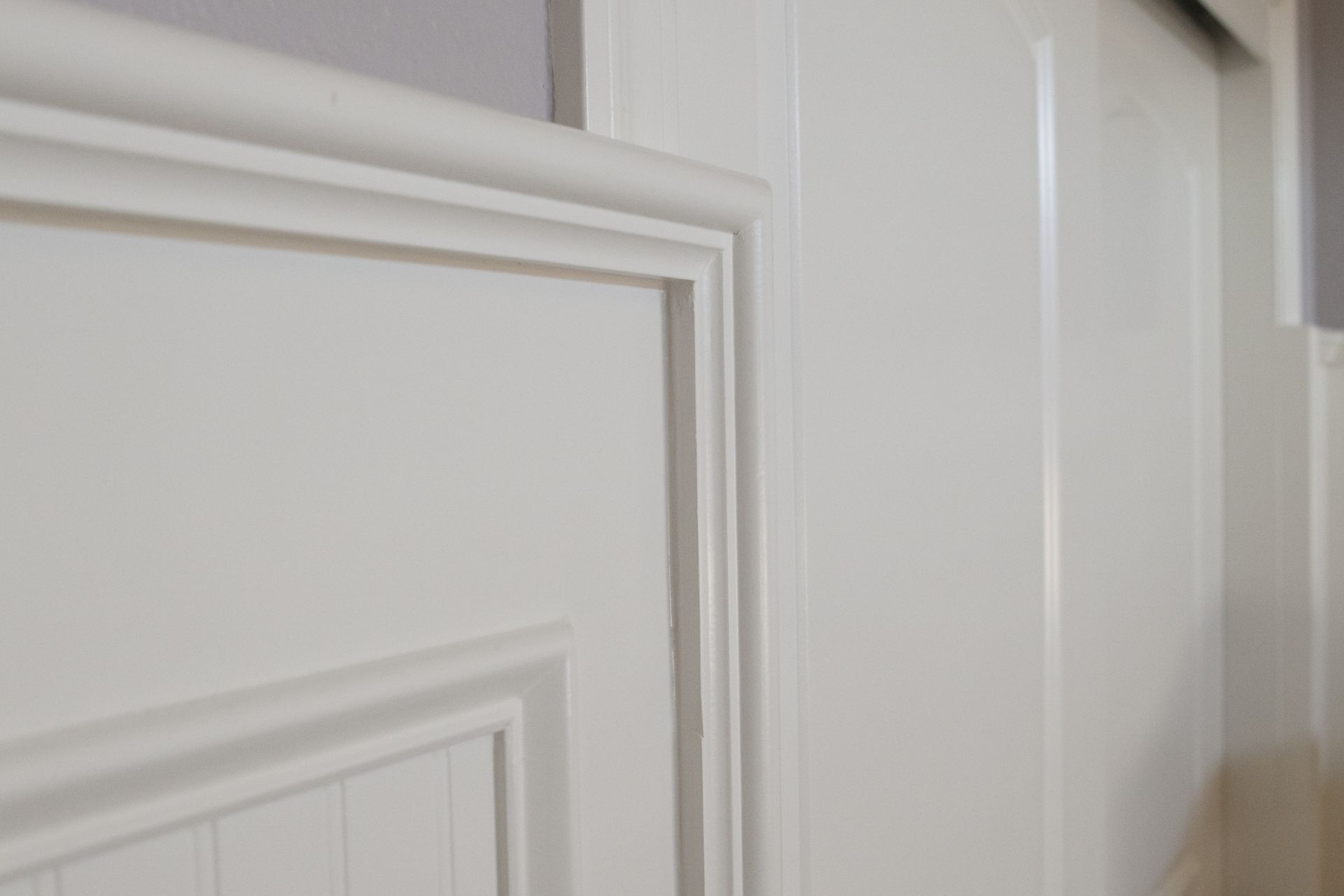 White paneled door with detailed trim and moulding.
