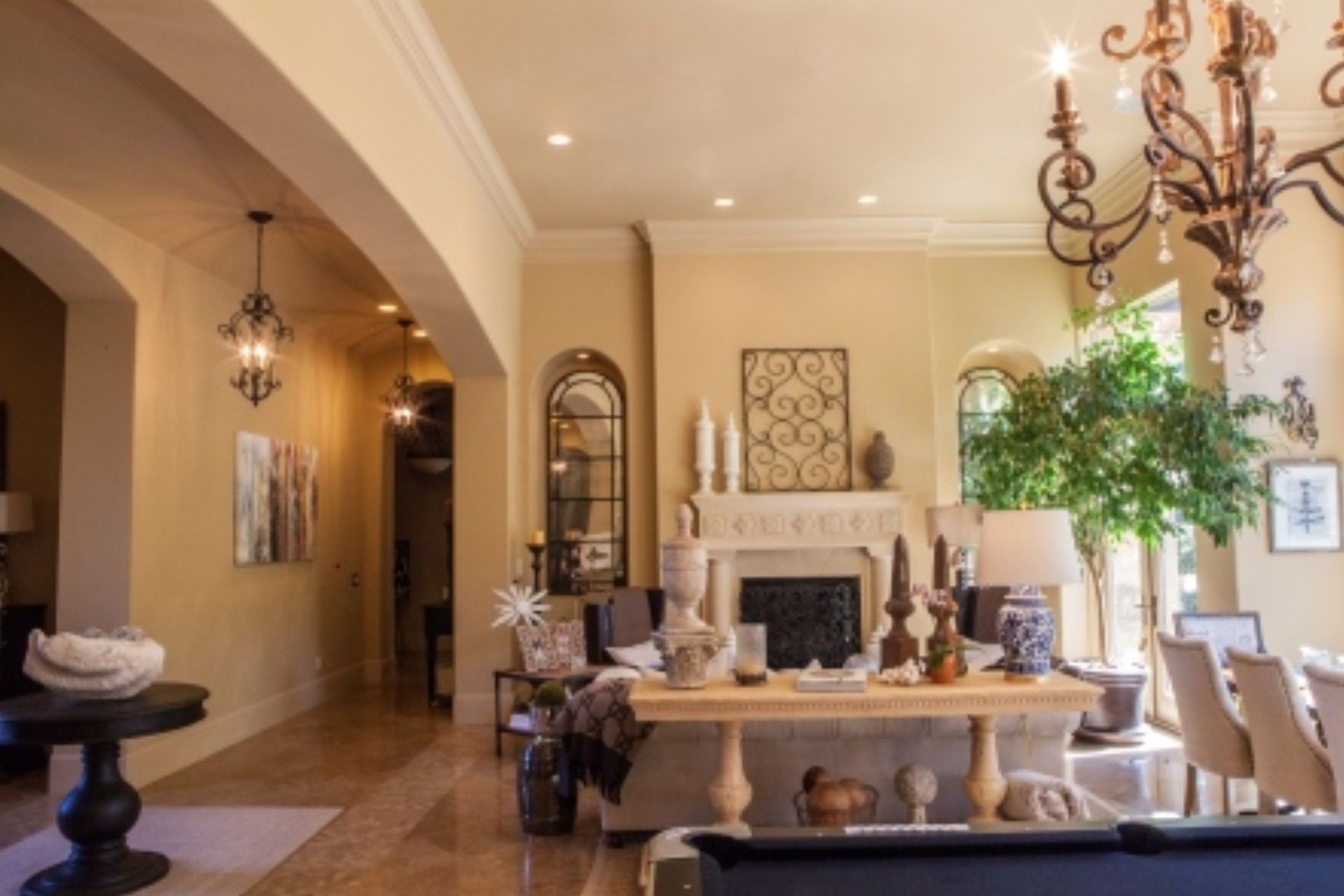 Elegant living room with chandelier, fireplace, neutral tones, and decorative elements.