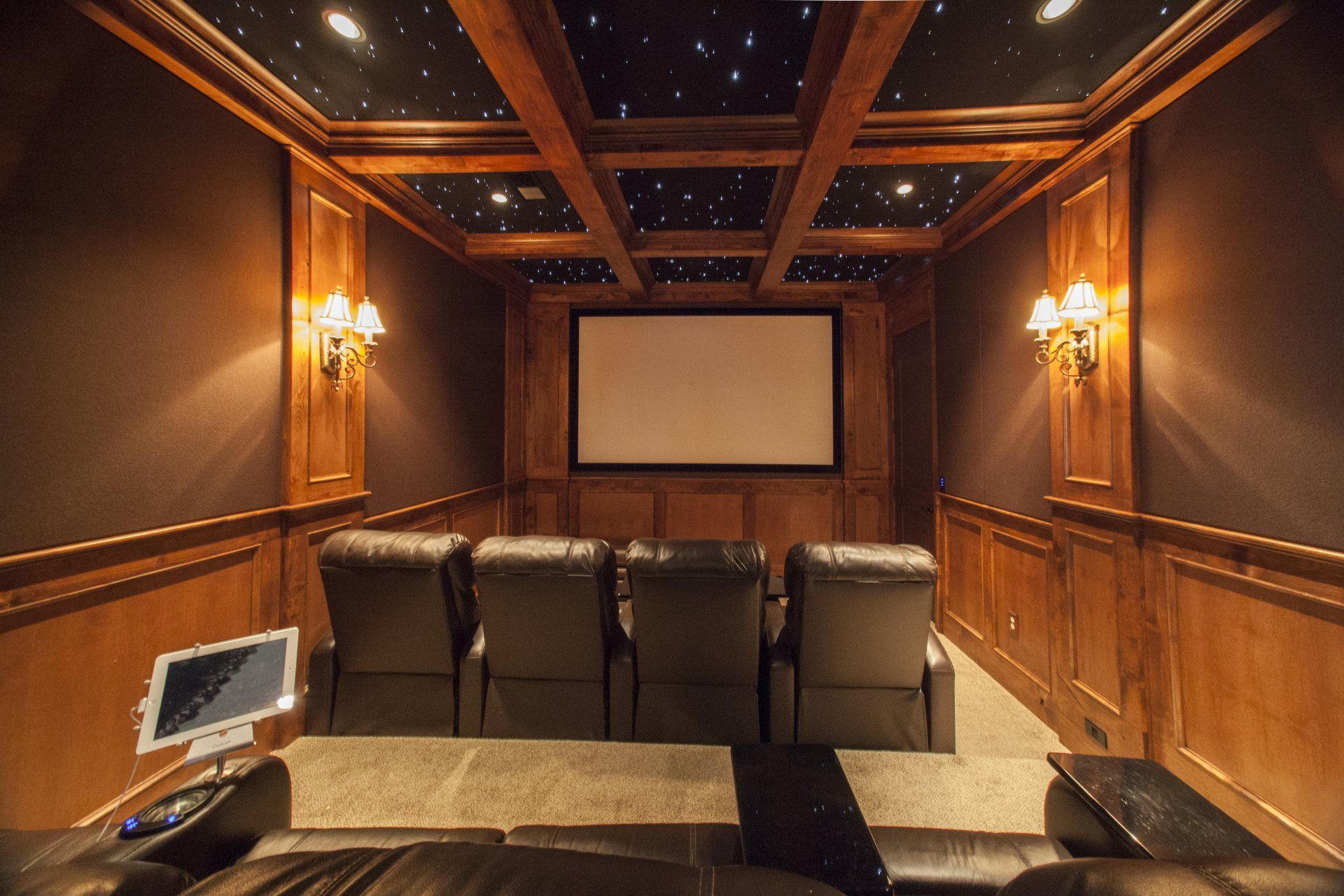 Home theater with brown paneling, leather recliners, and starry ceiling.