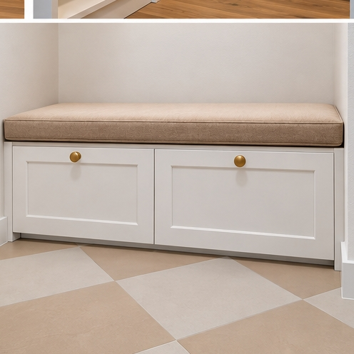 White built-in bench with beige cushion and gold knobs in a tiled entryway mudroom nook