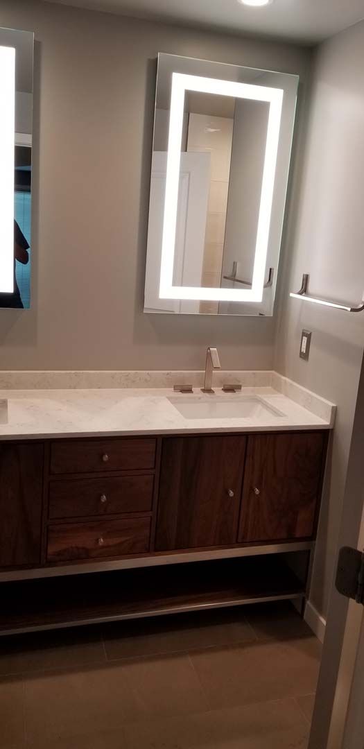 A bathroom with a sink , mirror and vanity.