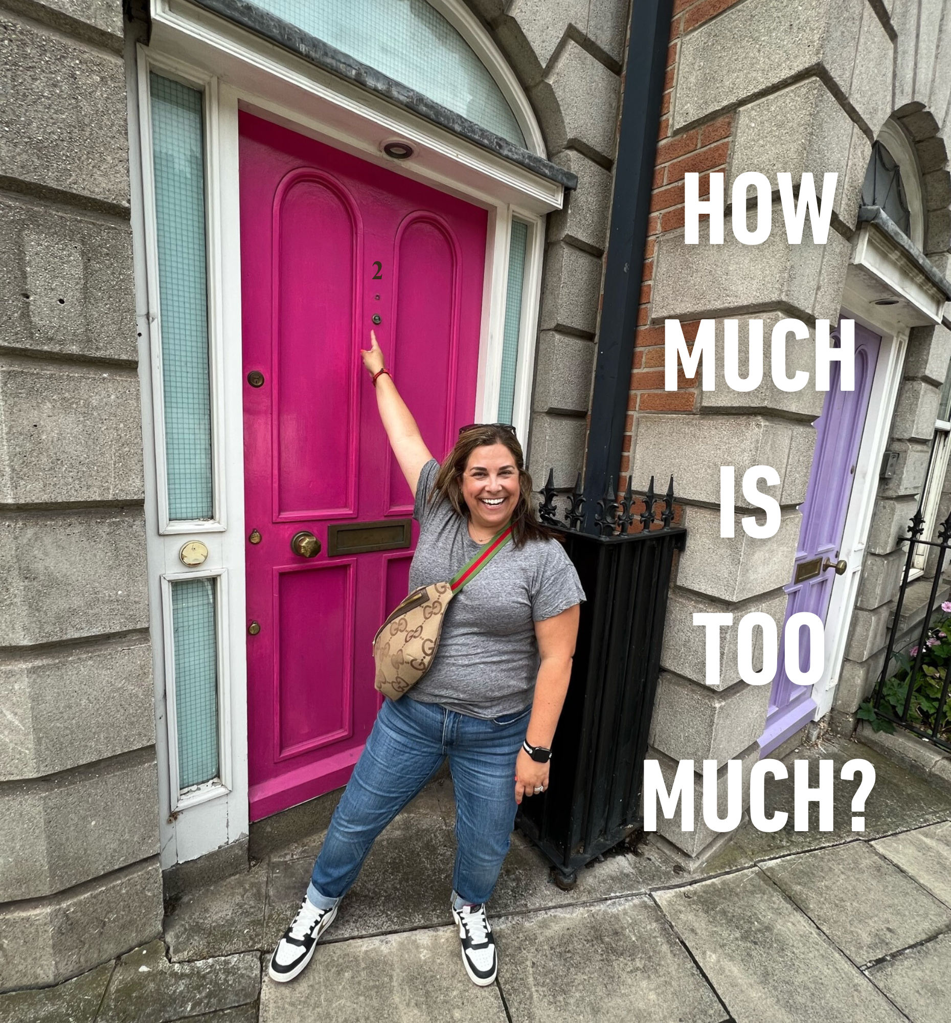 a woman is standing in front of a pink door.