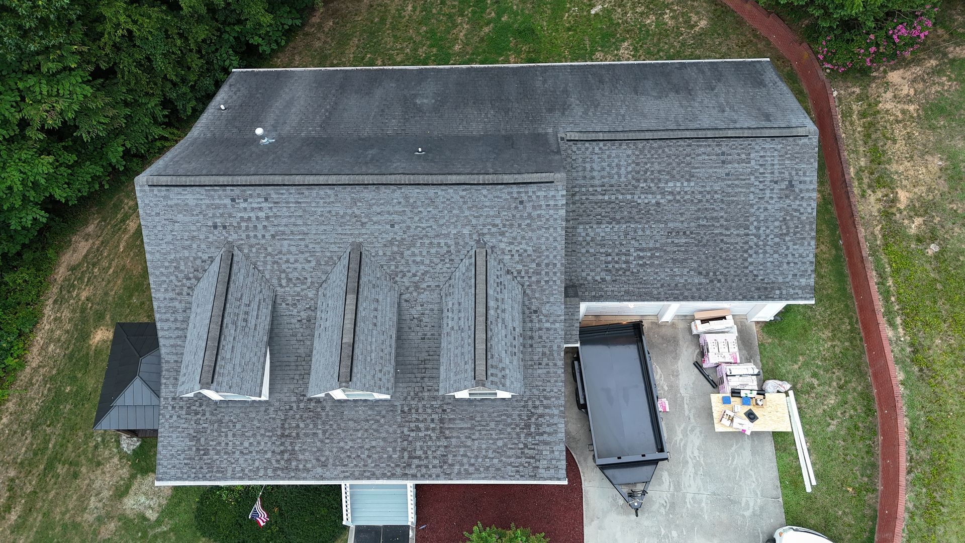 An aerial view of a house with a black truck parked in front of it.