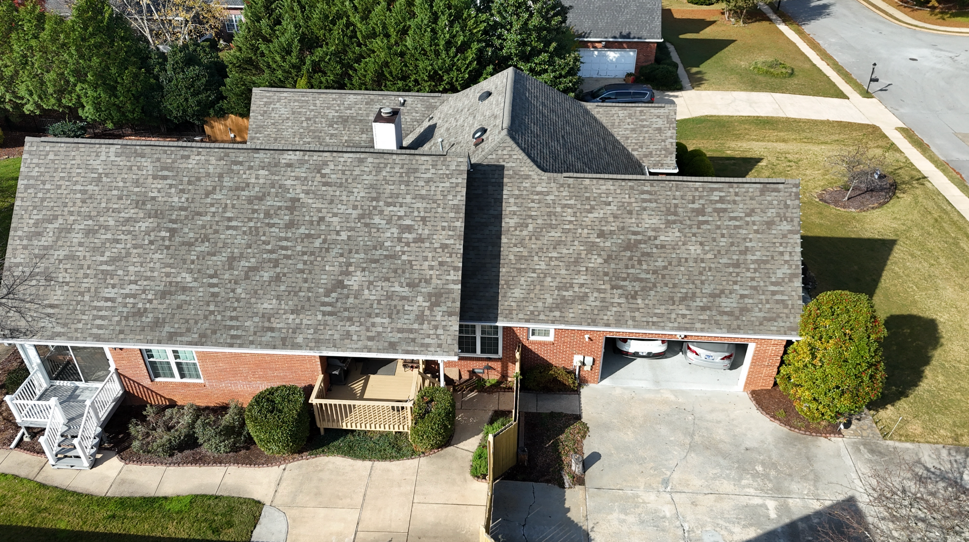An aerial view of a brick house with a new roof.