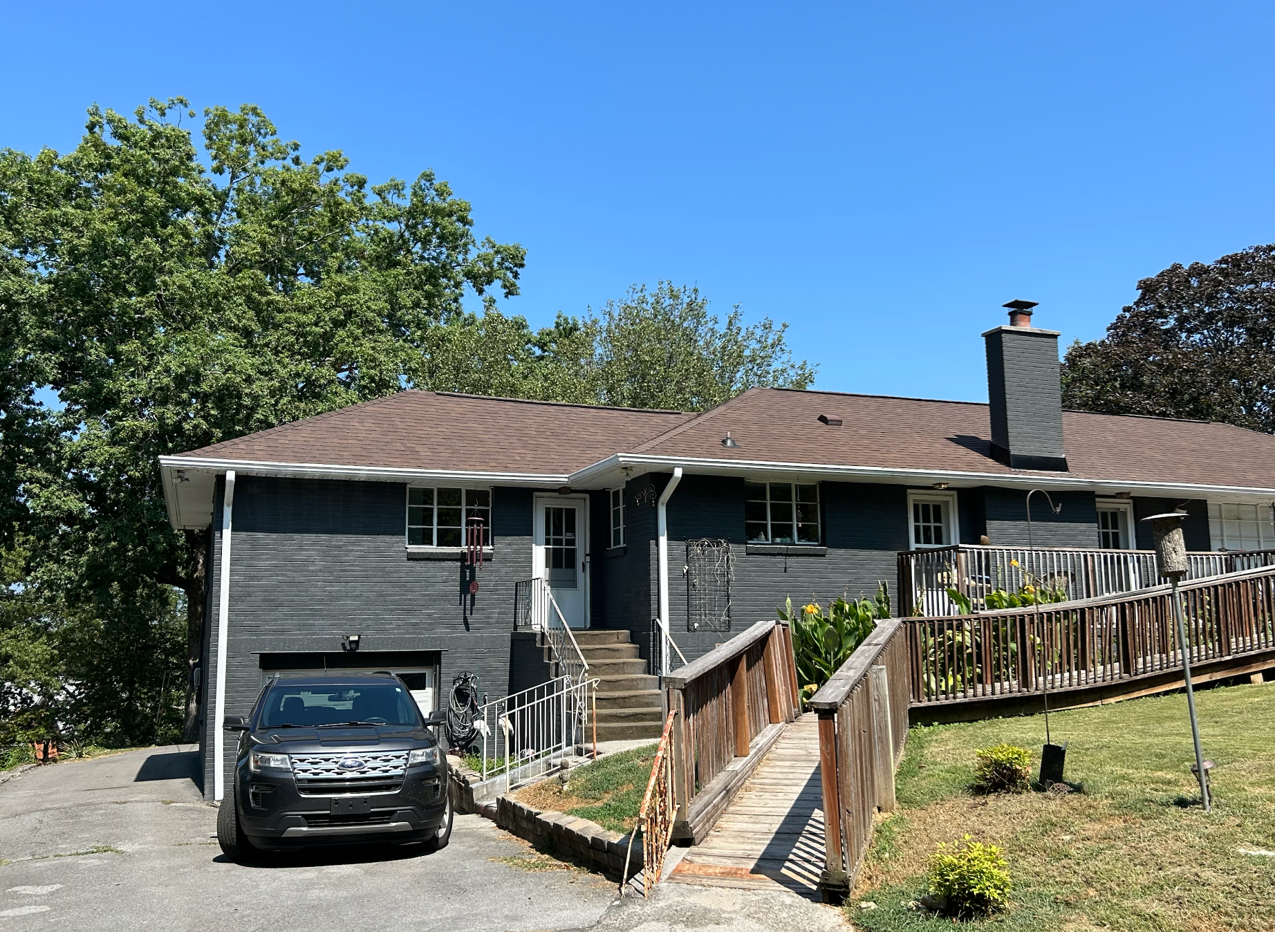 A car is parked in front of a house with a ramp leading to it.
